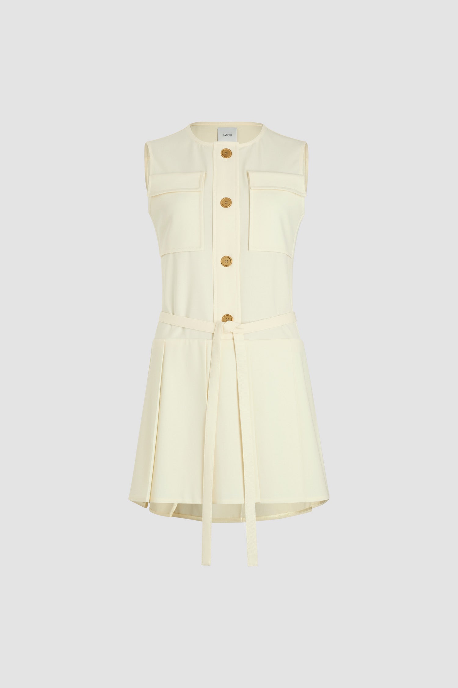 Patou - Robe courte plissée en sergé de laine technique éco-responsable - Ivory - Robe en sergé de laine technique éco-responsable ivoire. Modèle court. Encolure arrondie. Modèle sans manches. Boutons dorés gravés avec le monogramme JP sur le devant. Ceinture longue à nouer à la taille. Jupe plissée.