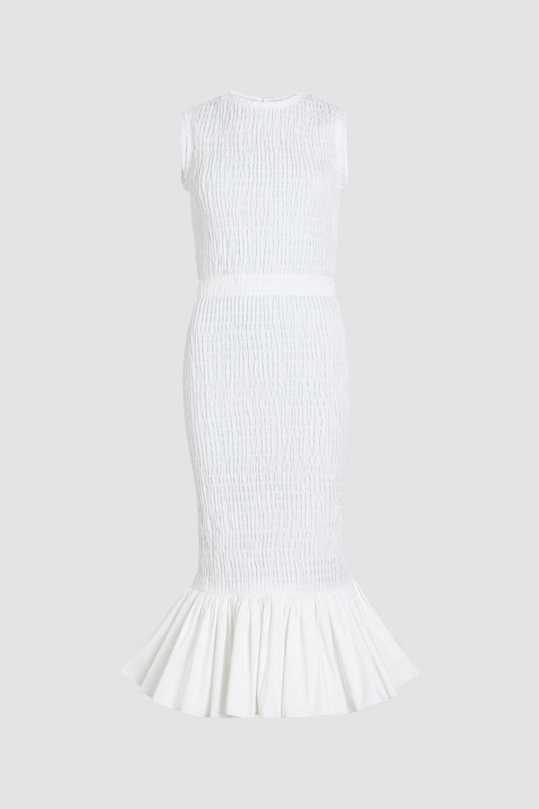 Patou - Robe midi smockée à ourlet volanté en faille recyclé - White - Robe en faille recyclée blanche. Longueur midi. Silhouette ajustée. Modèle sans manches. Zip doré au dos. Taille élastiquée. Ourlet volanté. Cette robe fait partie de la collection Cérémonie créée pour les occasions spéciales.