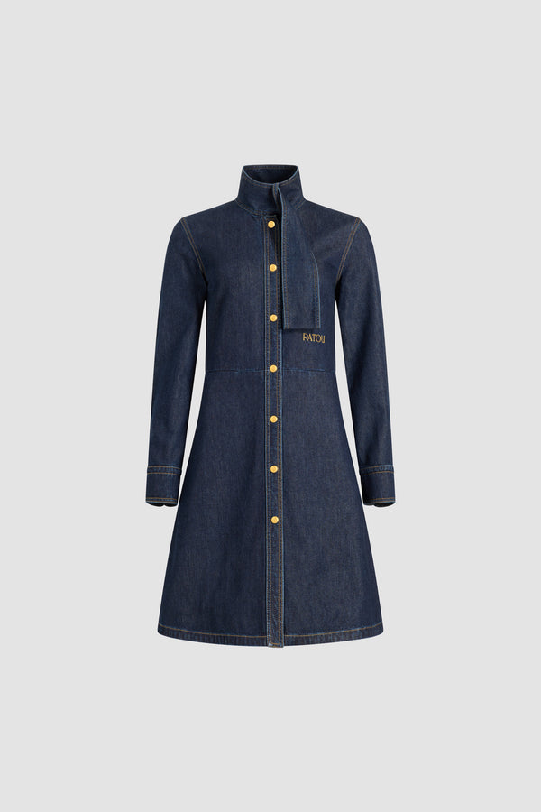 Patou - Robe chemise à col foulard en denim de coton mélangé - Blue Moon Rodeo - Robe en denim de coton mélangé bleu nuit rodéo. Motif rayé. Longueur genou. Silhouette ajustée et évasée. Col foulard avec à l’avant. Fermeture par bouton dissimulé à l’avant. Logo Patou brodé à la taille. Poignets boutonnés. Poches latérales.