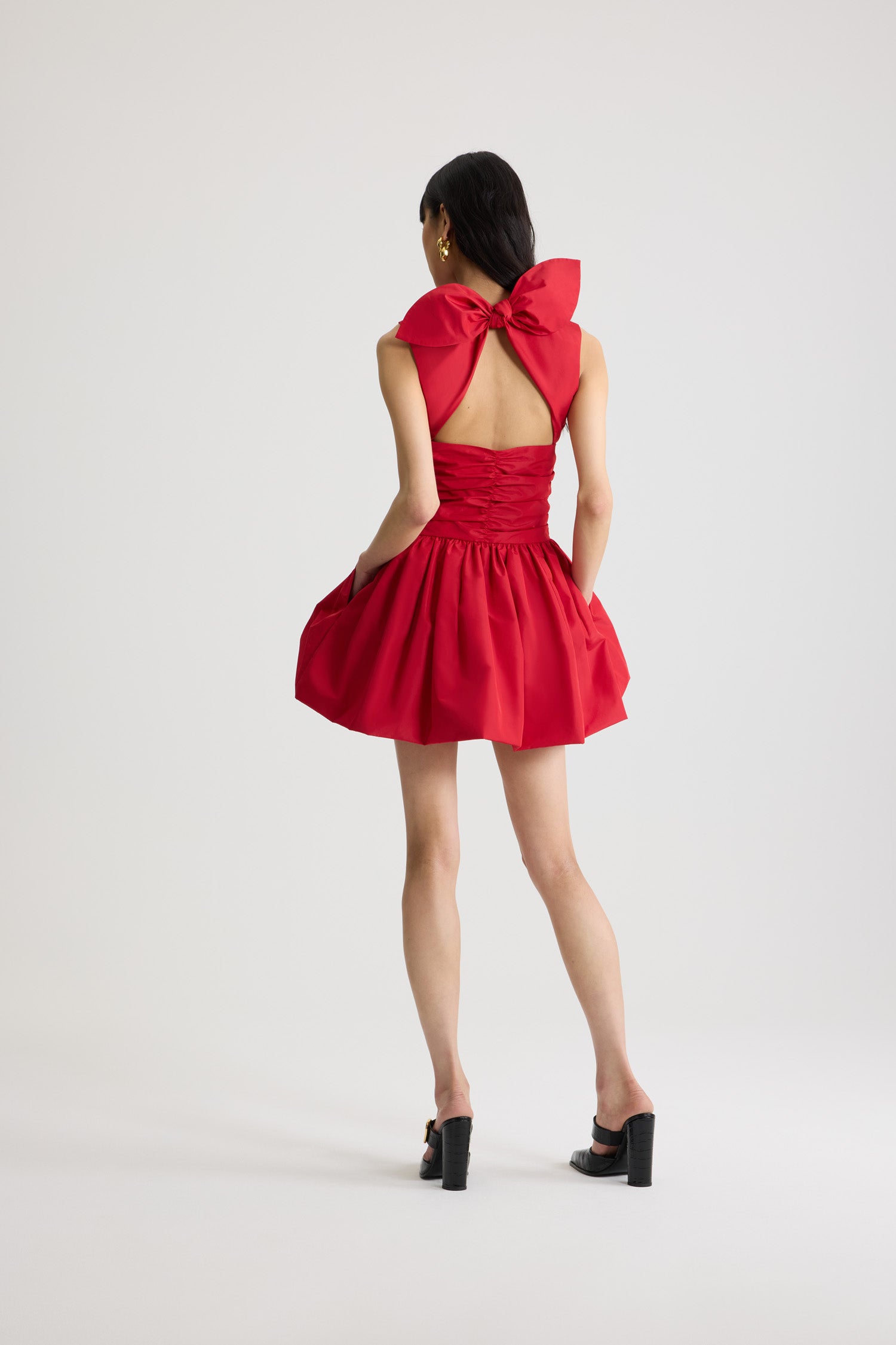 Patou - Mini robe dos nu avec noeud en polyester recyclé - Lipstick Red - Mini robe couleur rouge à lèvres en polyester recyclé. Dos nu ornée d’un nœud. Jupe de style bloomer. Cette pièce est issue de la Capsule "Evening", pensée par Guillaume Henry : pour immortaliser des occasions spéciales avec style et raffinement.