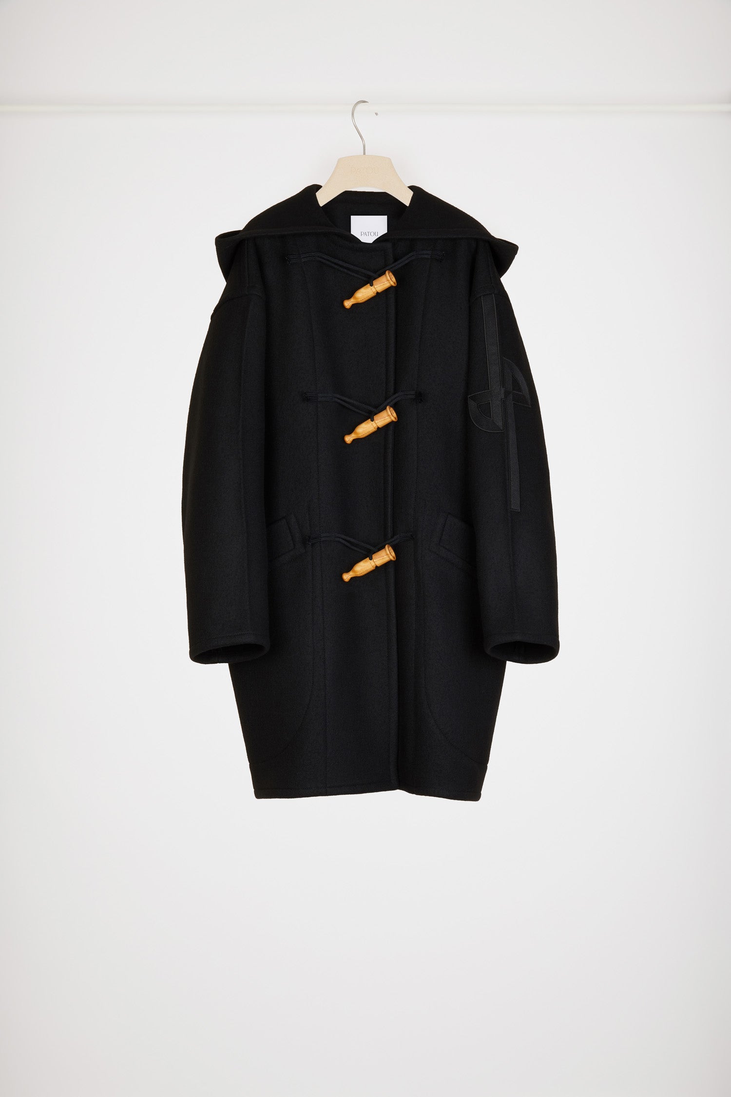 Patou - Cashmere and wool blend duffle coat - Black - Wool and whistles.Black cashmere and wool duffle coat. Crafted from recycled materials blended to achieve a softly worn look over time. Oversized silhouette. Hooded collar. Fastens via wooden buttons shaped like bird calls as well as concealed press buttons. Stylised JP logo embroidered in black on the left sleeve. Oversized patch pockets.
