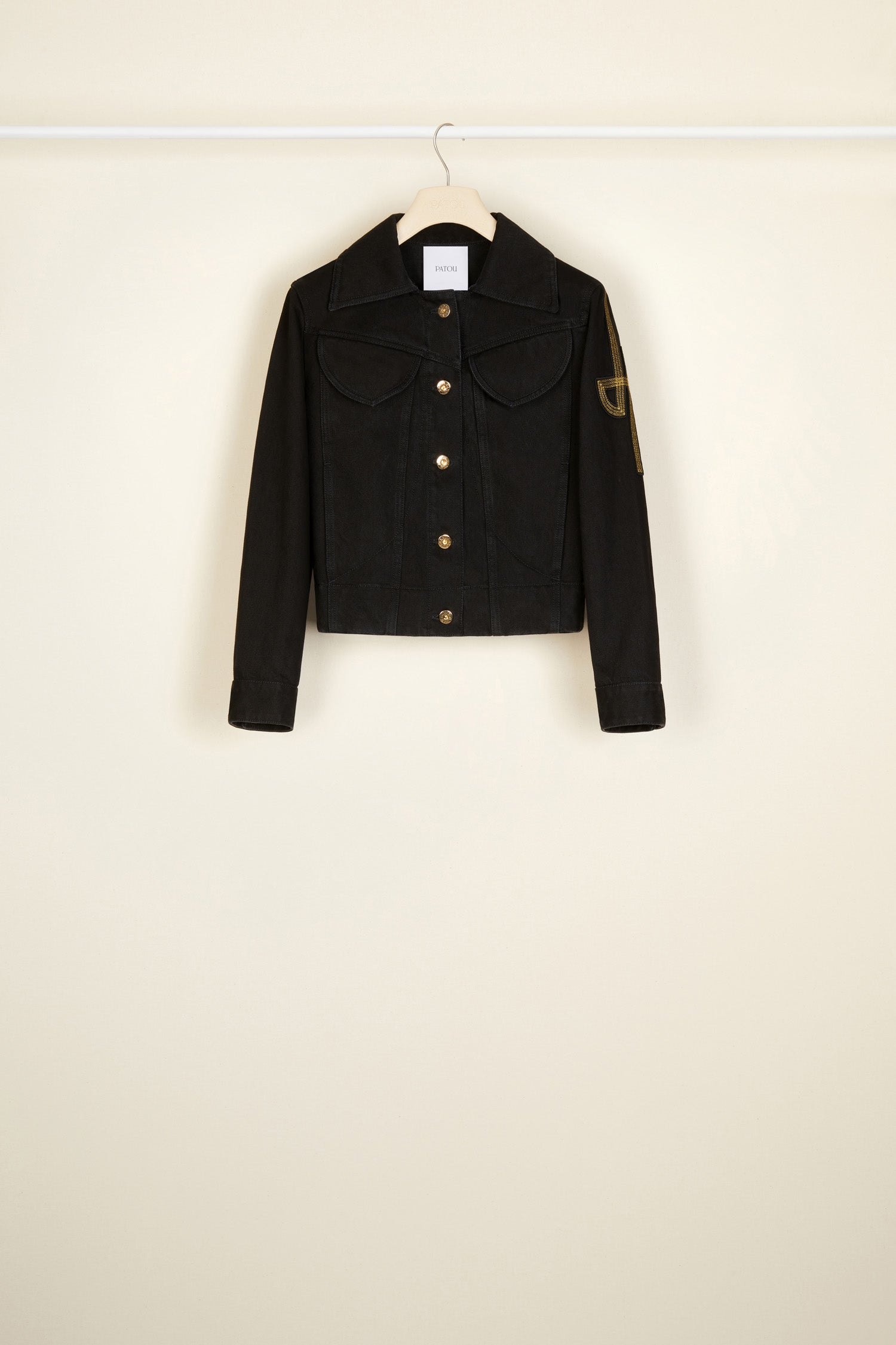 Patou - オーガニックデニム 刺繍ロゴジャケット - Black - ゴールドの文字をまとう新しいデニムがパトゥから登場。 フィットスタイルのオーガニックブラックデニム製ジャケット、コントラストカラーのステッチ入り。左袖にオリジナルJPロゴの刺繍。フロント、ウエスト、袖口にエングレーヴィング入りのゴールドカラーボタン。胸にフラップポケット2個、サイドポケット2個。