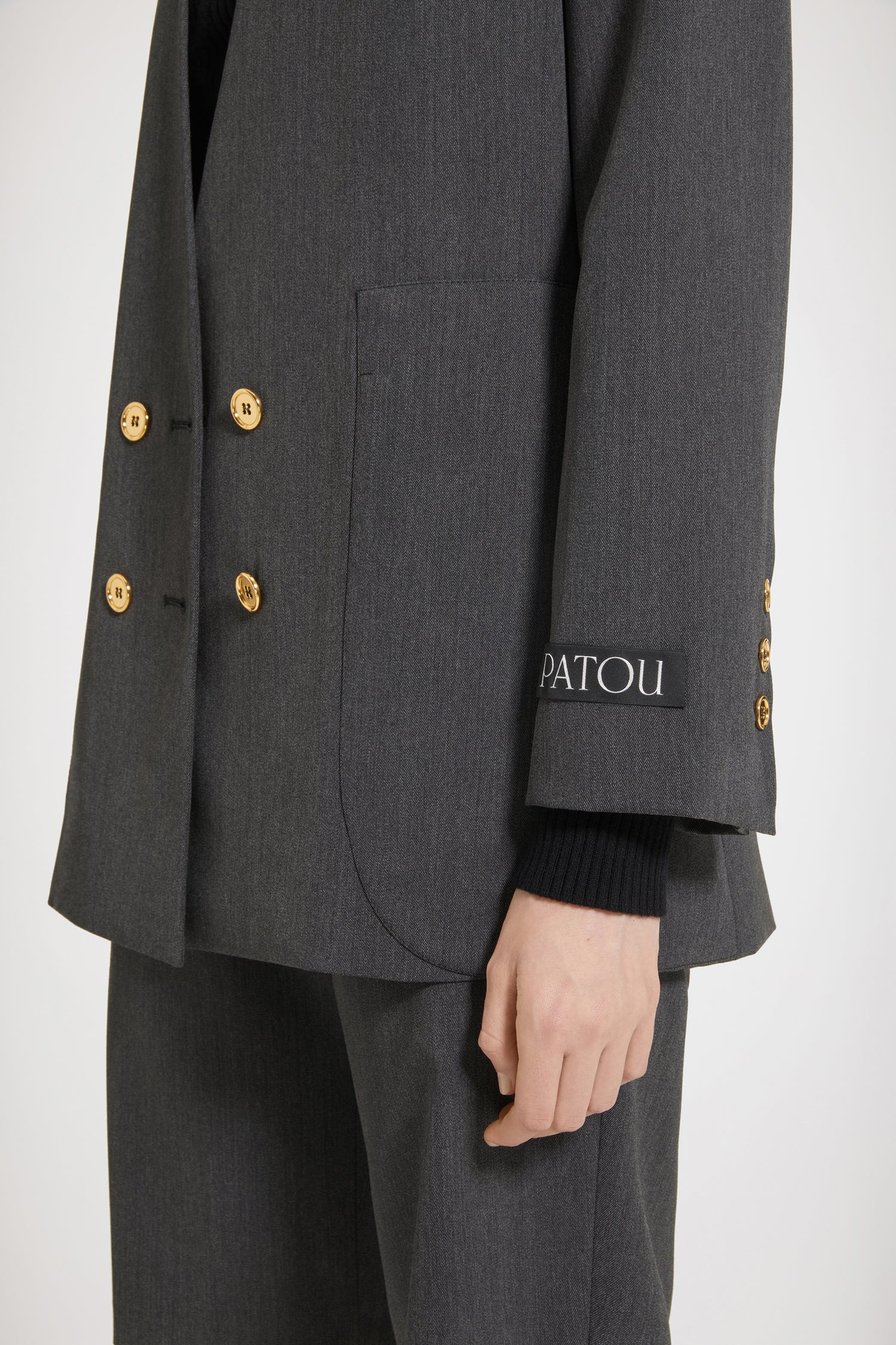 Patou - Kragenlose doppelreihige Jacke aus technischem Wolltwill - Anthracite - Die kragenlose (R)Evolution.Jacke aus technischem Wolltwill in Anthrazitgrau. Doppelreihig geknöpft. Kragenloses Design. Goldfarbene Knöpfe mit JP-Gravur vorne und an den Ärmelabschlüssen. Einschubtaschen an der Brust, zwei aufgesetzte Oversize-Taschen. Patou Aufnäher auf dem linken Ärmel. Vollständig gefüttert.