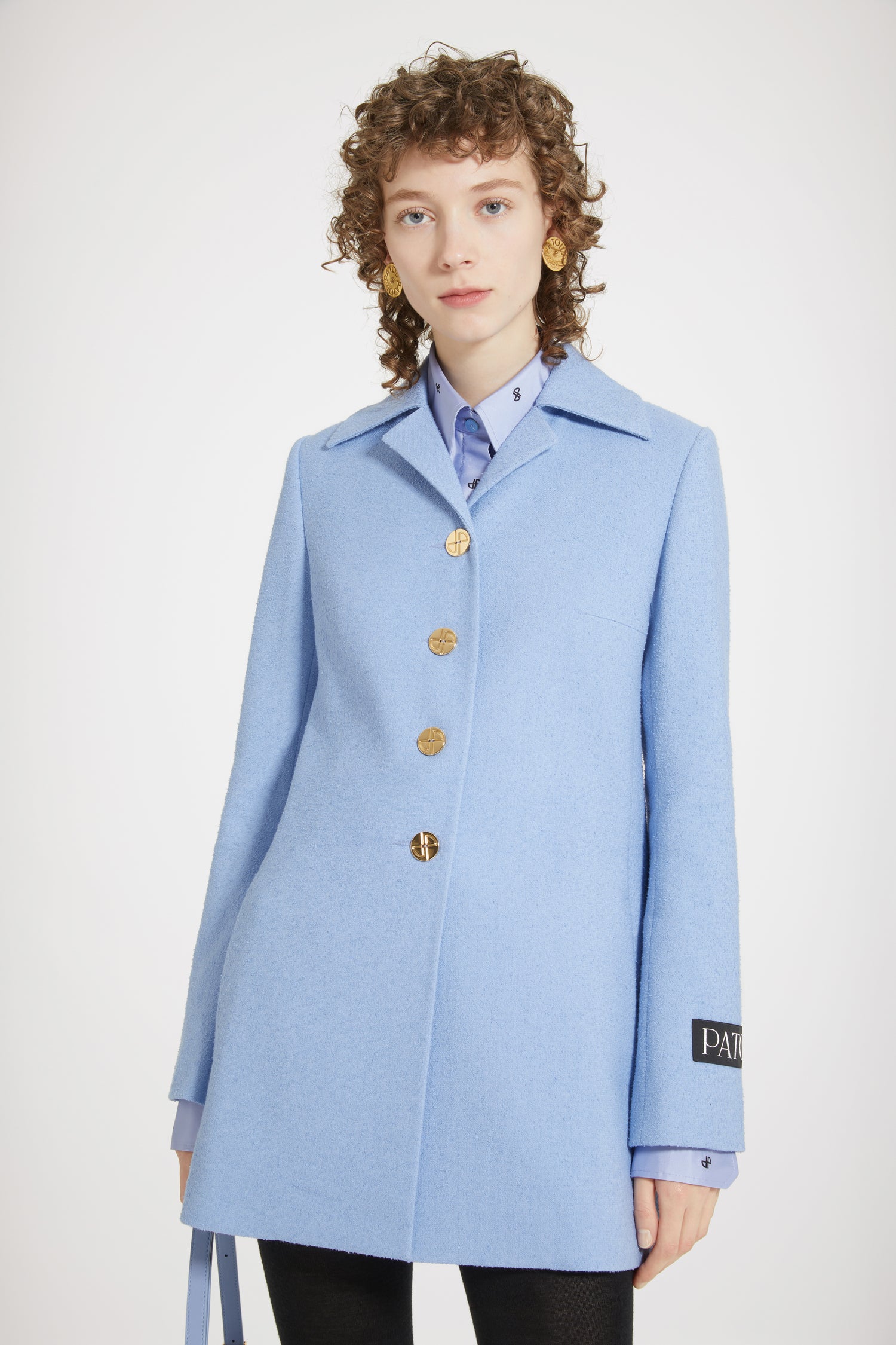 Patou - Longline jacket in stretch tweed - Ice Blue - Tweed, elongated and elevated.Ice Blue stretch tweed jacket. Longline silhouette. Wide collar with small lapels. Art Deco-style gold-tone JP-engraved buttons. Darts at the chest. Gold-tone zips with signature JP puller at the cuffs. Patou label on the left sleeve. Single vent at the back. Fully lined.Tight fit at the shoulders.