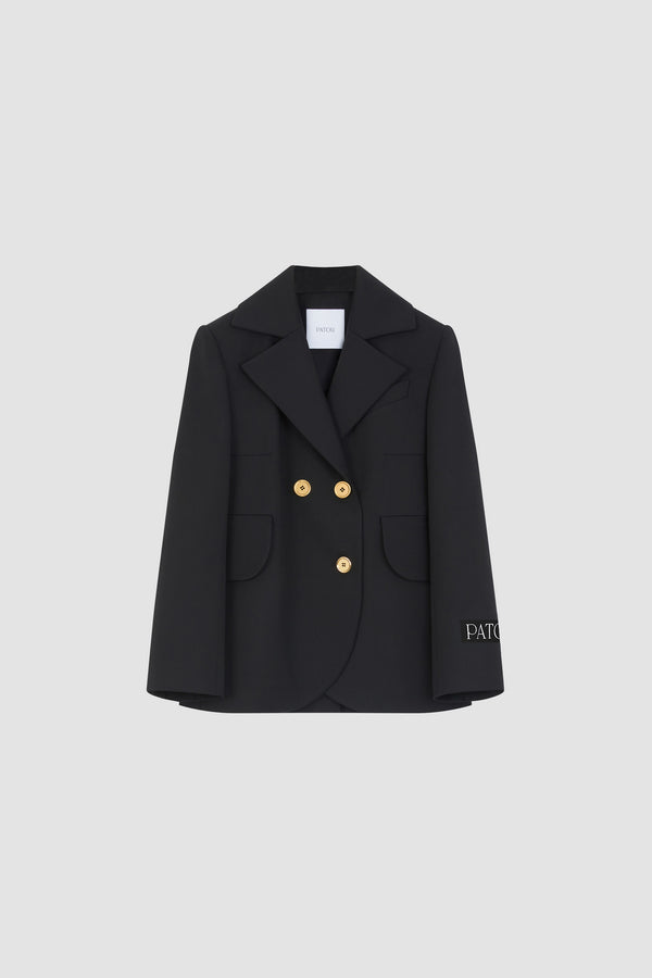 Patou - Taillierte Jacke mit Gürtel aus nachhaltiger technischer Wolle - Black - Schwarze Jacke aus nachhaltigem technischem Wolltwill. Doppelreihig geknöpft. Jackett-Silhouette. Fallendes Revers. Goldfarbene Knöpfe mit Patou Logogravur. Taillengürtel aus Stoff. Pattentaschen. Verkürzte Ärmel. Patou Logoetikett auf dem linken Ärmel.