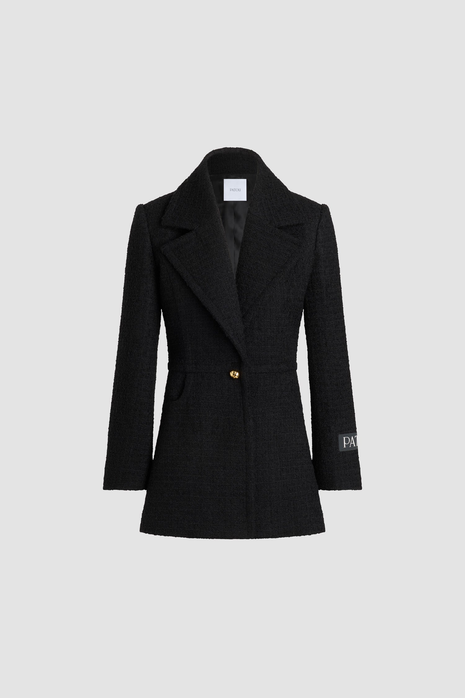 Patou - Longline single-breasted jacket in sustainable wool blend tweed - Black - Black sustainable wool blend tweed jacket. Long tailored silhouette. Single-breasted construction. Wide notch lapel. Single gold-tone half-sphere JP monogram button. Patou logo label on the left sleeve. Buttoned cuffs. Lined