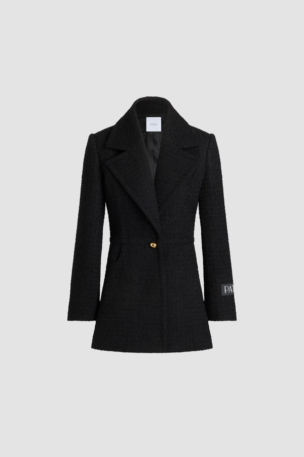 Patou - Veste longiligne à boutonnage simple en tweed de laine mélangée éco-responsable - Black - Veste en tweed de laine mélangée éco-responsable noir. Silhouette ajustée longue. Construction à boutonnage simple. Revers crantés larges. Un bouton boule doré à monogramme JP. Étiquette Patou sur la manche gauche. Poignets boutonnés. Modèle doublé