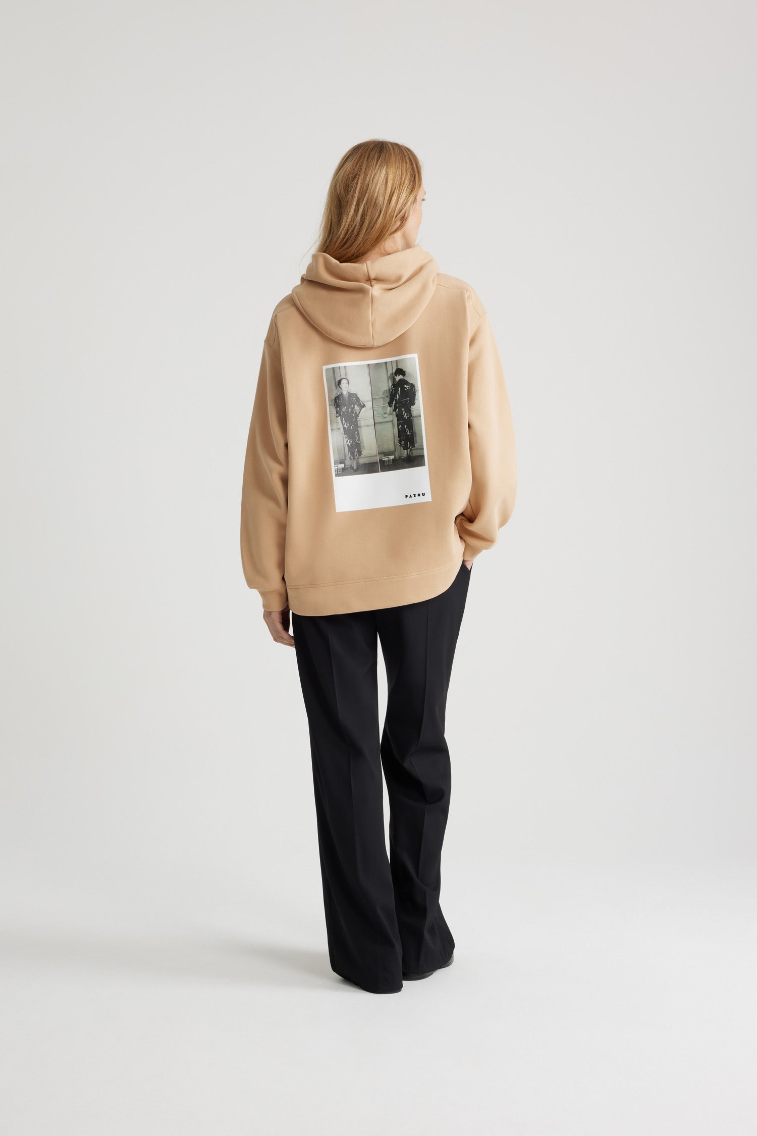 Patou - Grosgrain-Kapuzenpullover aus Bio-Baumwolle aus dem Archiv - Biscuit - Kapuzenpullover in Biscuit Beige aus Bio-Baumwolle. Unisex-Stil. Kapuzenkragen mit Zugband aus Ripsband. Tief angesetzte Ärmel. Lookbook-Fotos aus dem Archiv als Print auf der Rückseite in Art déco Patou. Patou und JP als Stickereien vorne. Manschetten und Saum gerippt.Dieses Modell weist eine Oversize-Passform auf. Für einen körperbetonenden Stil bitte eine Größe kleiner wählen.