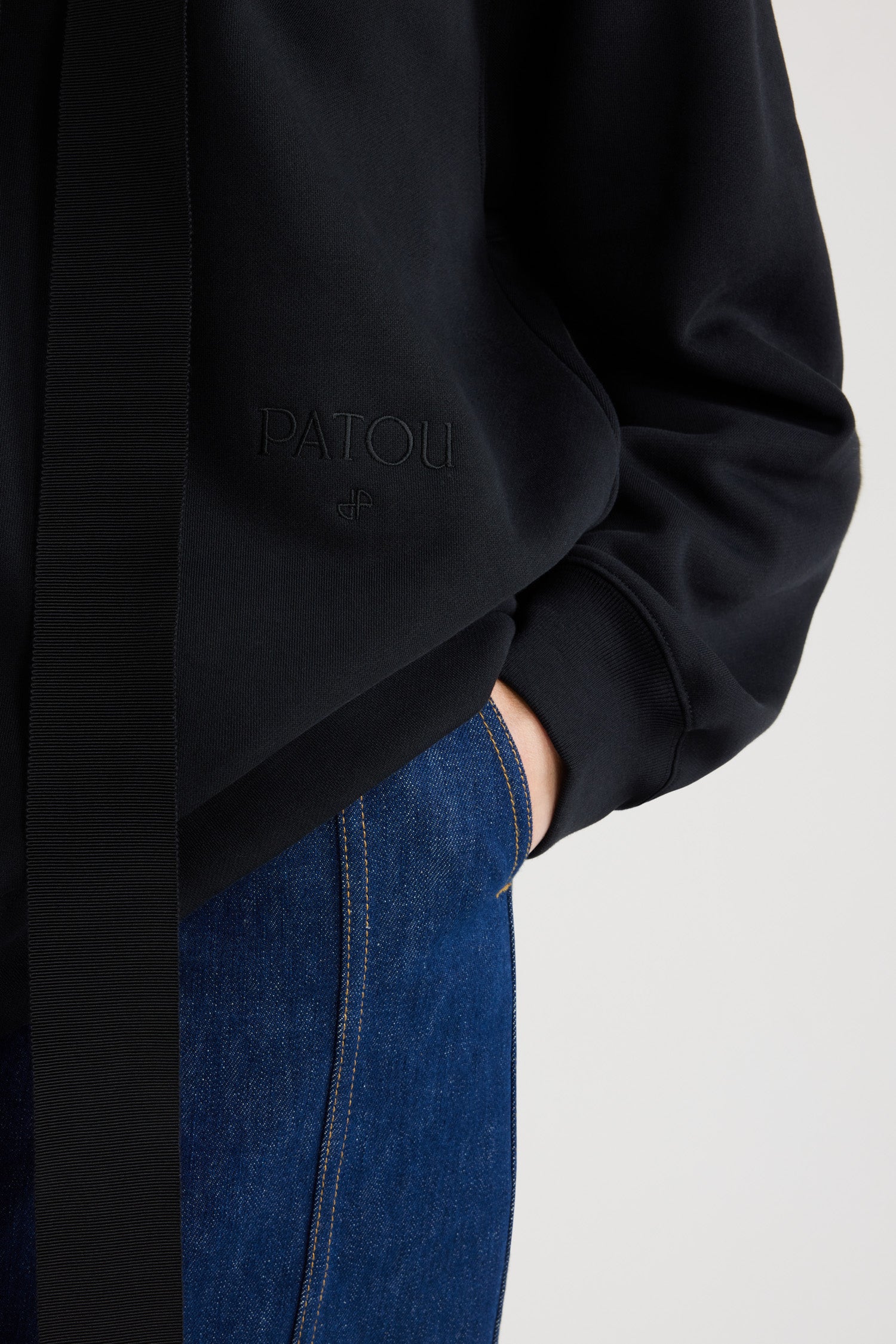 Patou - Felpa Archivio in cotone bio - Black - Felpa in cotone bio nero. Modello unisex. Collo con cappuccio e lacci in grosgrain. Foto di lookbook d'archivio stampate sul retro con Patou in stile Art Déco. Patou e JP ricamati sul davanti. Polsini e orlo a costine.Questo modello è oversized; scegliere una taglia in meno per una vestibilità classica.