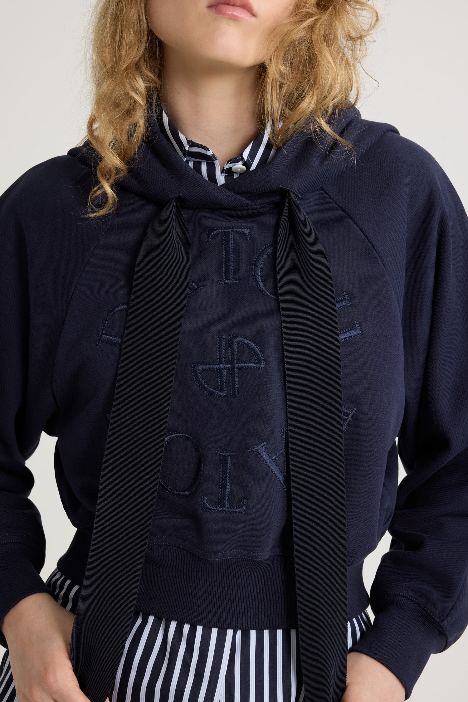 Patou - Sweatshirt à logo médaillon en coton bio - Navy Black - Sweatshirt en coton bio noir marine. Silhouette décontractée. Col à capuche avec coulisse en gros-grain. Logo Patou médaillon brodé sur le devant. Manches raglan. Poignets et ourlet côtelés.