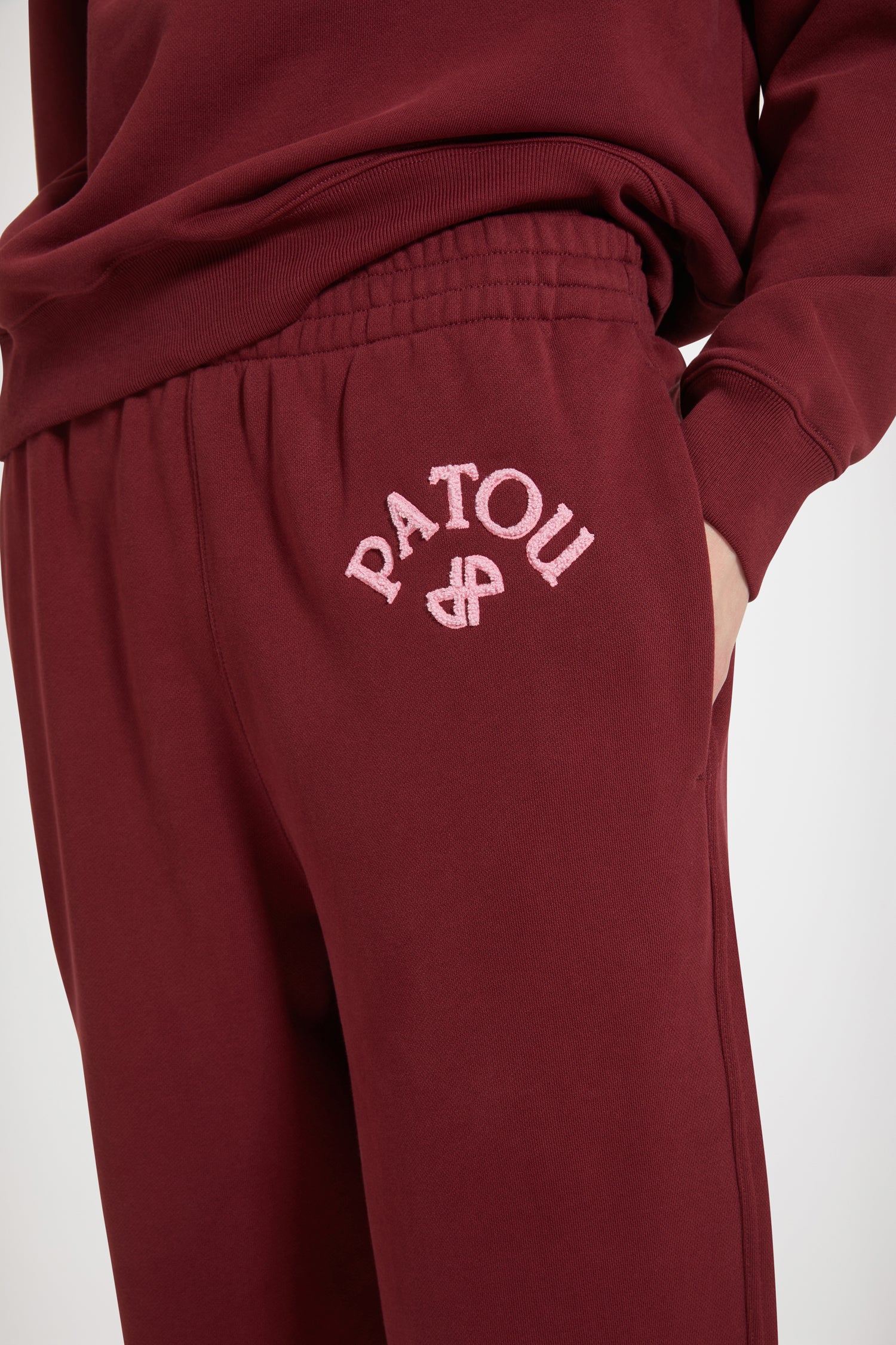 Patou - Bouclette embroidery tracksuit trousers in organic cotton - Ruby Wine - The tracksuit refined and redefined.Ruby Wine organic cotton trousers. High rise. Straight leg. Elasticated waist with hidden herringbone drawstring. 3D mélange bouclette Patou and JP embroidery. Pockets at the sides.Can be worn at the waist or on the hips.
