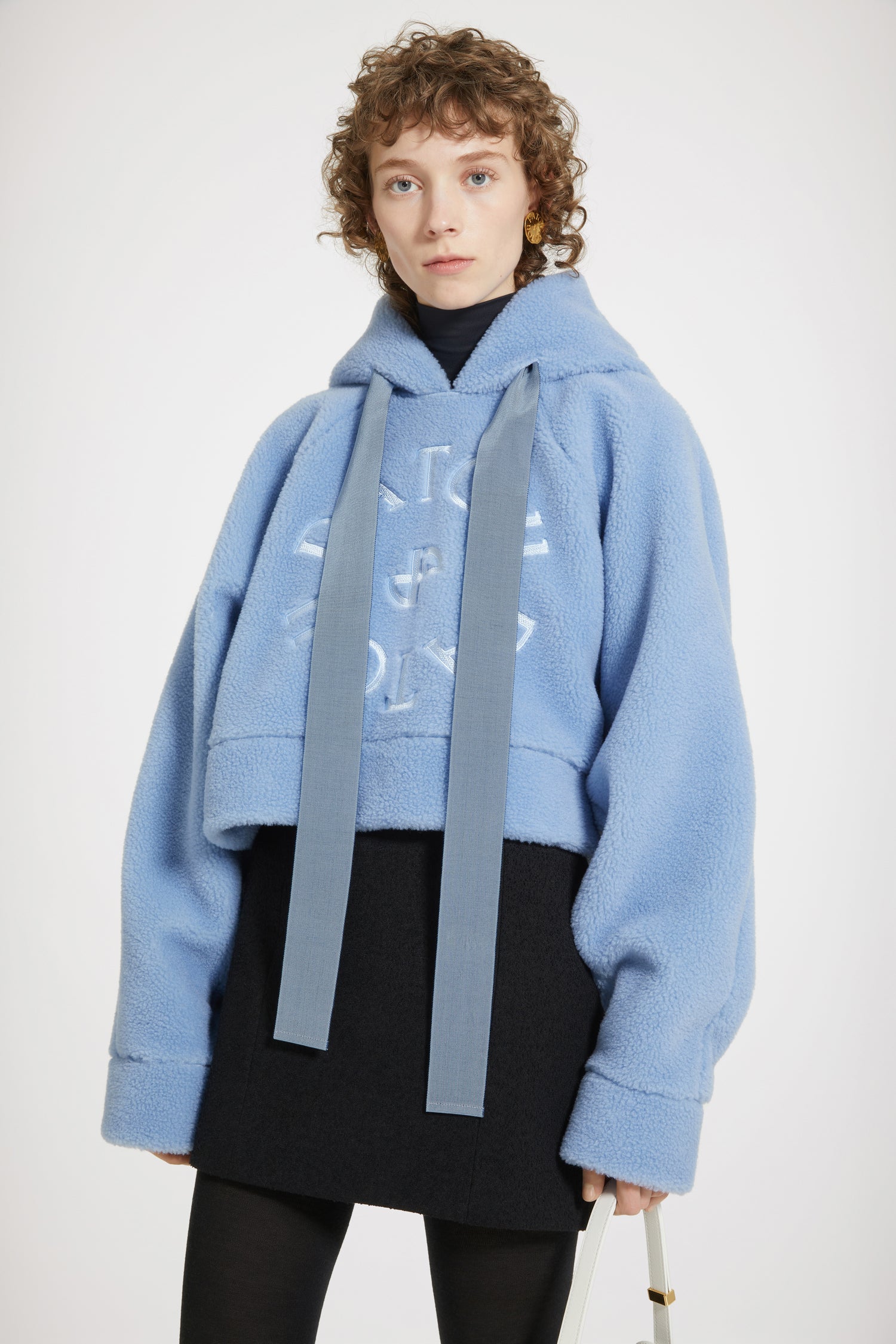 Patou - Sweatshirt à capuche  Médaillon en faux shearling recyclé - Ice Blue - Le parfait doudou des filles en Patou.Sweatshirt à capuche en polyester recyclé bleu glacier. Imitation shearling. Silhouette décontractée légèrement raccourcie. Col à capuche avec liens en gros-grain. Logo Patou médaillon brodé sur le devant. Manches raglan. Poignets et ourlet côtelés.Sweatshirt légèrement crop.