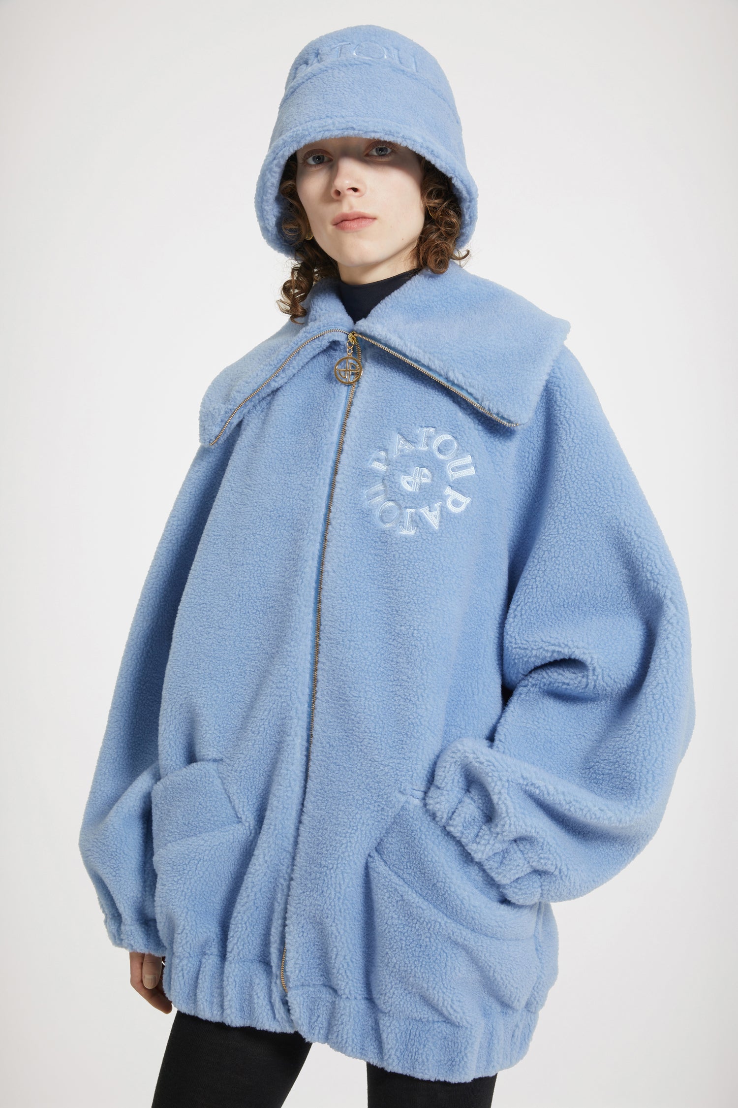 Patou - Bomber en faux shearling recyclé - Ice Blue - Le chic en shearling.Bomber en polyester recyclé bleu glacier. Imitation shearling. Silhouette oversize. Grand col. Zip doré avec tirette JP signature. Logo Patou médaillon brodé sur la poitrine. Poches plaquées sur le devant. Poignets et taille élastiqués.Modèle oversize.