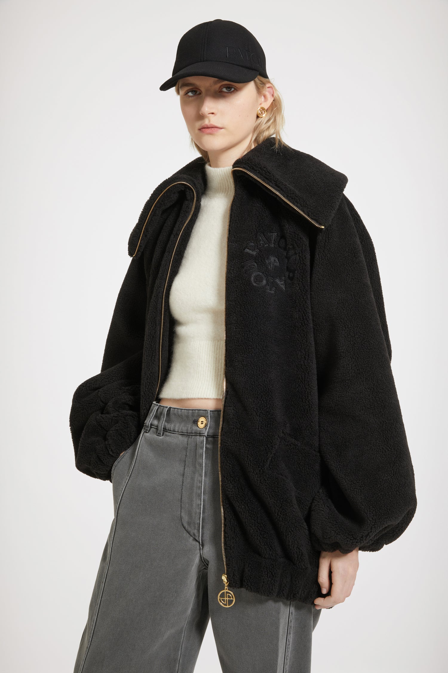 Patou - Bomber en faux shearling recyclé - Black - Le chic en shearling.Bomber en polyester recyclé noir. Imitation shearling. Silhouette oversize. Grand col. Zip doré avec tirette JP signature. Logo Patou médaillon brodé sur la poitrine. Poches plaquées sur le devant. Poignets et taille élastiqués.Modèle oversize.