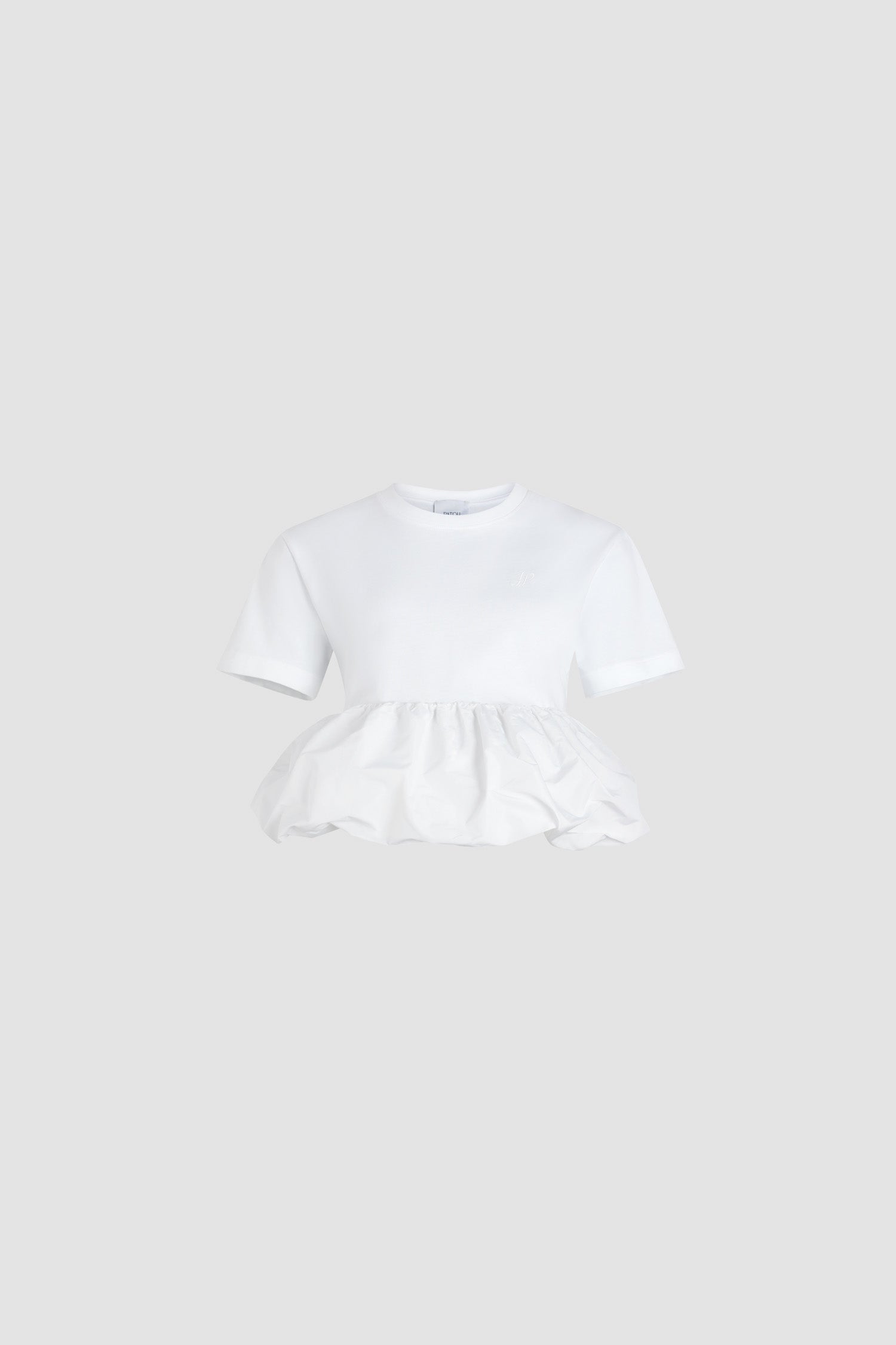 Patou - Ruffle hem t-shirt in organic cotton and faille - White - White organic cotton t-shirt. Thick jersey. Mixed media design with a contrast faille hem. Crewneck. Embroidered JP calligraphy monogram at the chest. Ruching at the waist.