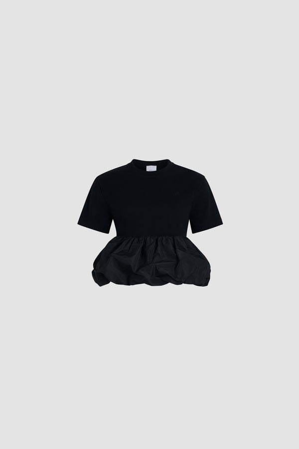 Patou - T-shirt à volant en coton bio et faille - Black - T-shirt en coton bio noir. Jersey épais. Modèle hybride avec volant en faille. Col rond. Monogramme JP calligraphie brodé à la poitrine. Fronces à la taille.