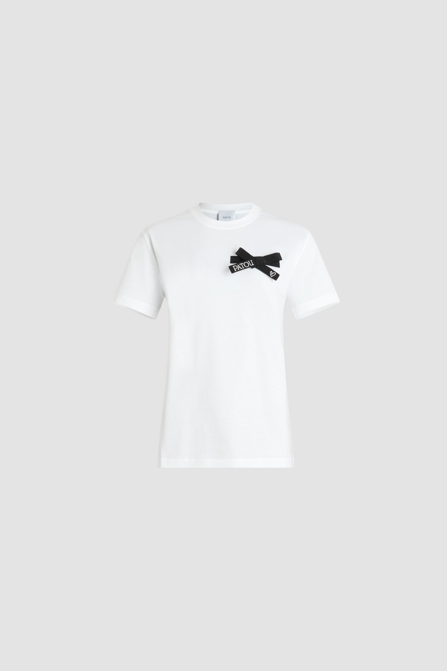 Patou - Bow t-shirt in organic cotton - Black - White organic cotton t-shirt. Regular fit. Crewneck. Black grosgrain bow at the chest with embroidered Patou logo and heart.