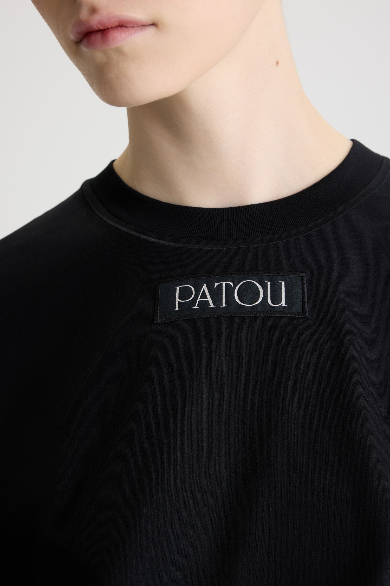 Patou - T-shirt con etichetta con logo Patou in cotone bio - Black - T-shirt in cotone bio nero. Vestibilità regular. Girocollo. Etichetta con logo Patou cucita sul davanti.
