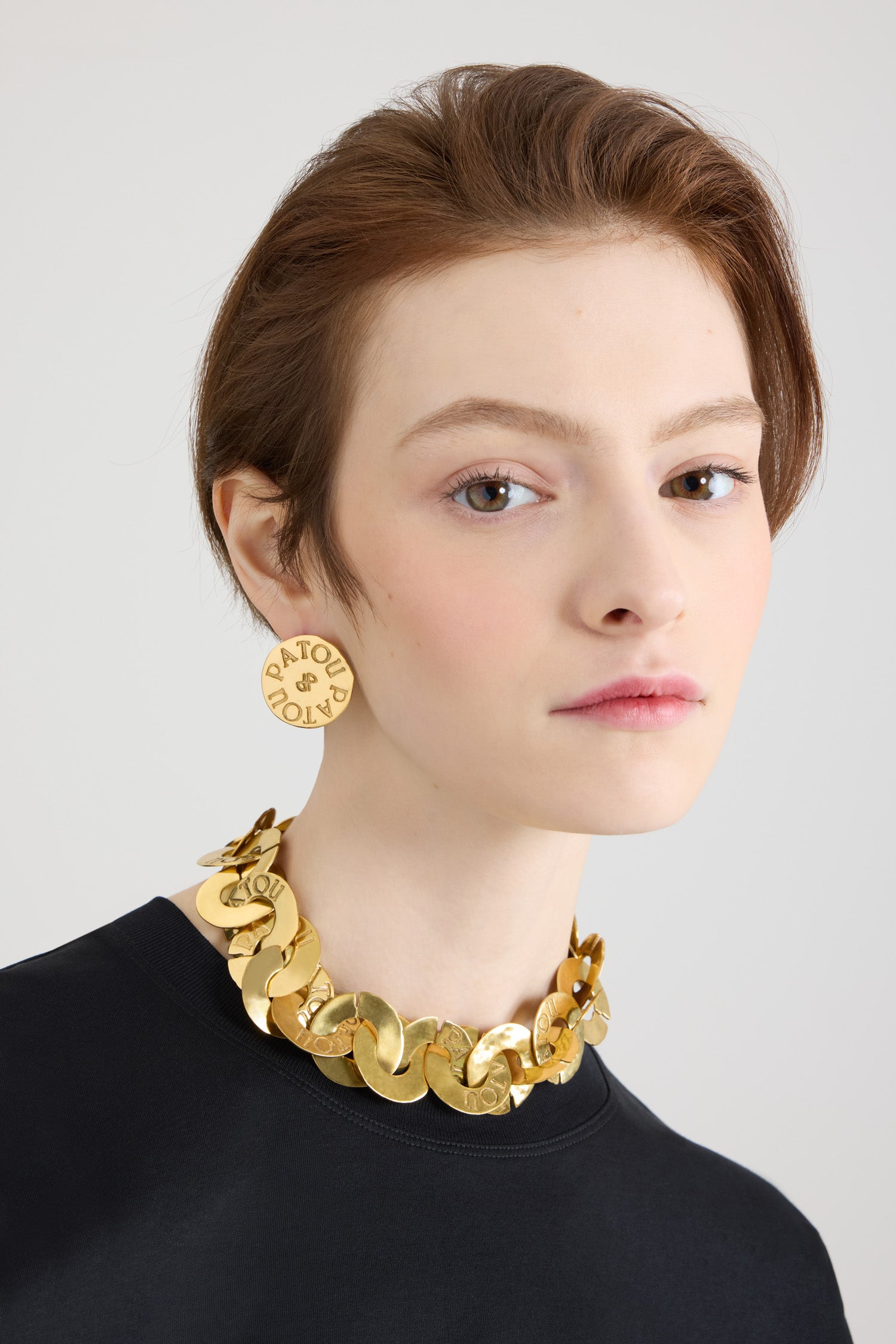 Patou - Ras-de-cou pièces en laiton doré - Gold - Collier en laiton doré. Inspiration pièces antiques. Effet martelé. Chaîne formée de pièces entrelacées gravées Patou. Fermoir T.