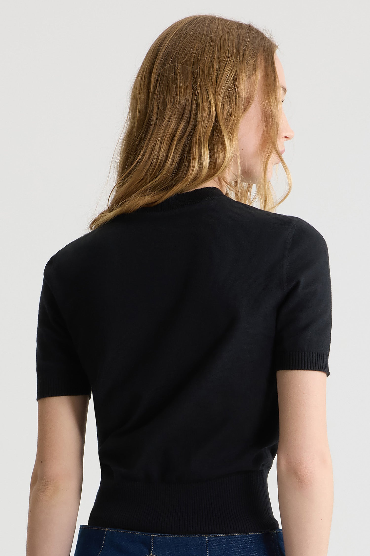 Patou - Top Patou in maglia ecosostenibile - Black - Patou scrive la sostenibilità in cinque lettere.Top in maglia di cotone bio nero. Vestibilità aderente. Maniche corte. Collo rotondo. Bordi a costine. Logo Patou e monogramma in jacquard sul fronte.