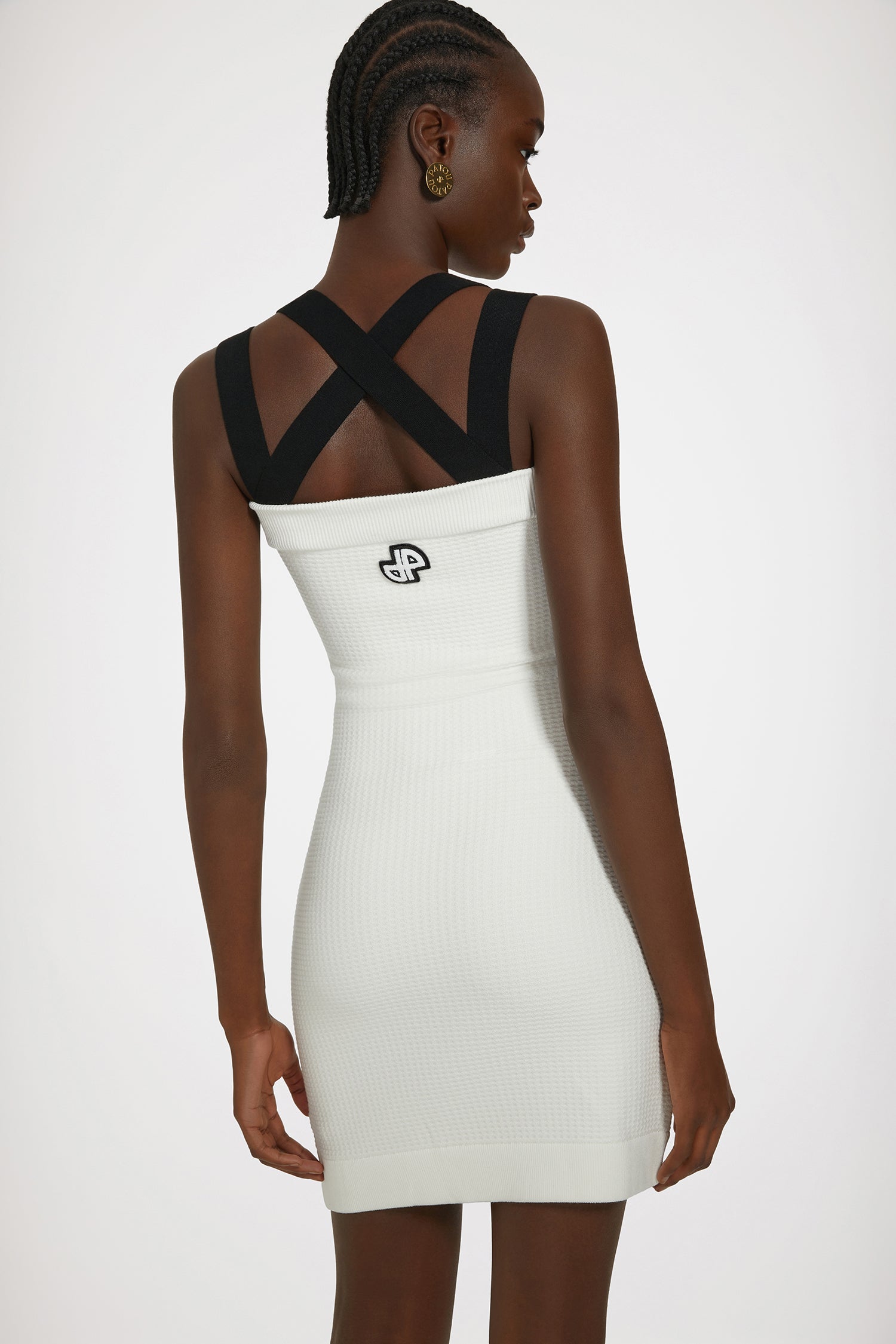 Patou - Robe à doubles bretelles en maille 3D - White - La maille redouble de bretelles et de style.Robe en maille blanche. Point 3D. Modèle court. Silhouette ajustée. Doubles bretelles croisées au dos. Fausses poches avec boutons Patou dorés. JP brodé au dos.Ce modèle est moulant.