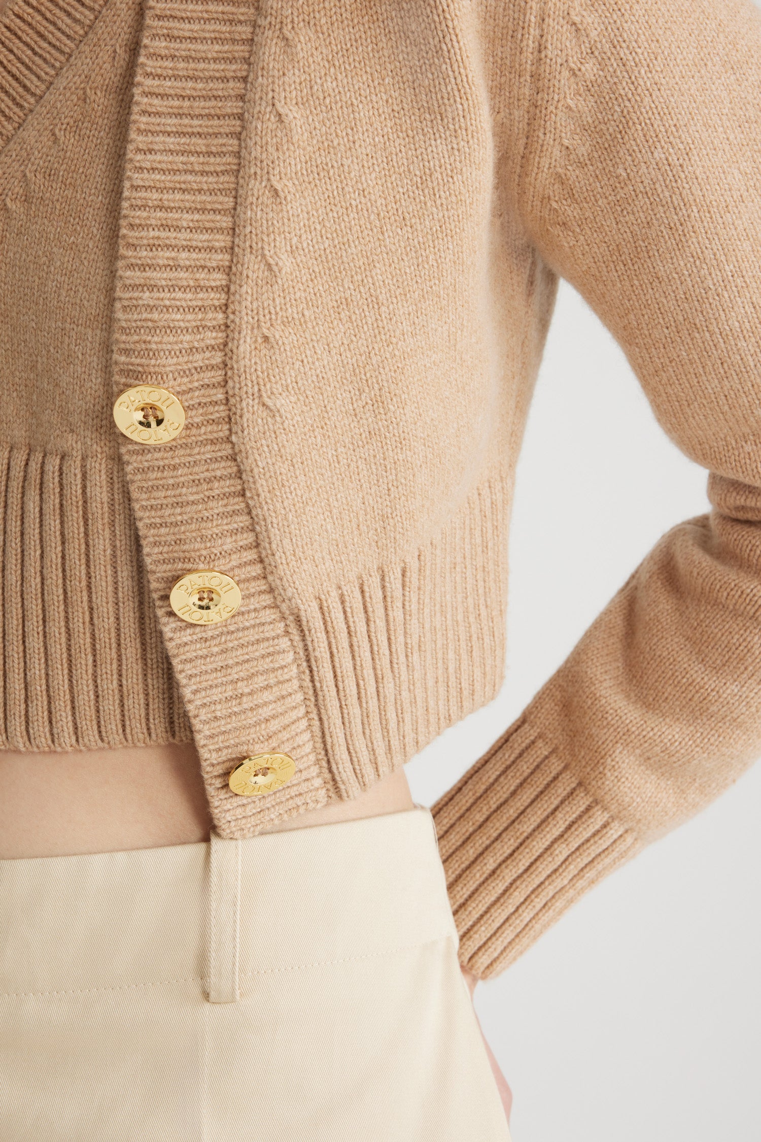 Patou - Cardigan corto in misto lana e cachemire ecosostenibile - Biscuit - Cardigan in misto lana e cashmere ecosostenibile beige biscotto. Modello corto. Scollo a V. Collo, polsini e orlo a costine. Bottoni oro incisi Patou. Toppe a contrasto sui gomiti.