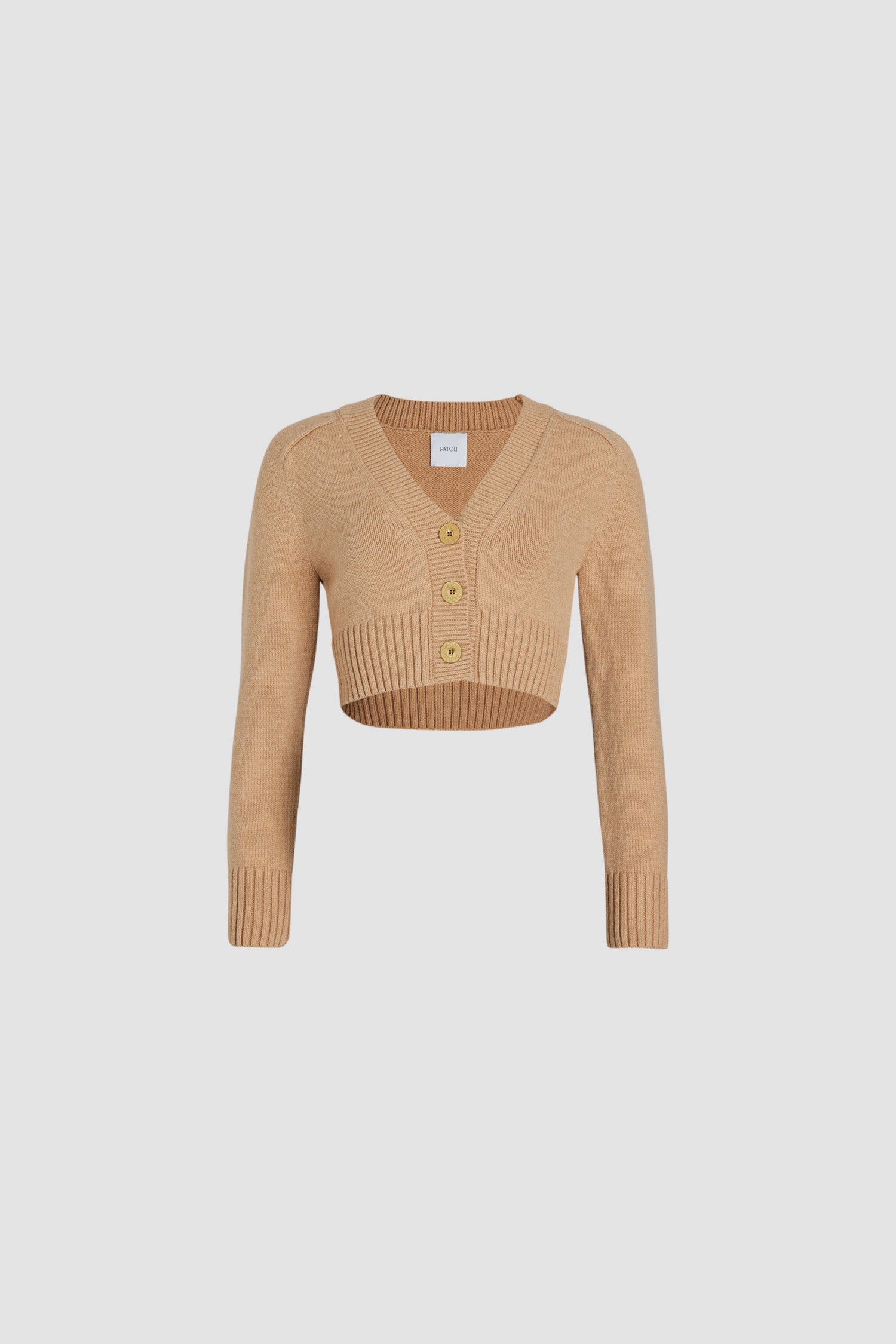Patou - Cardigan corto in misto lana e cachemire ecosostenibile - Biscuit - Cardigan in misto lana e cashmere ecosostenibile beige biscotto. Modello corto. Scollo a V. Collo, polsini e orlo a costine. Bottoni oro incisi Patou. Toppe a contrasto sui gomiti.