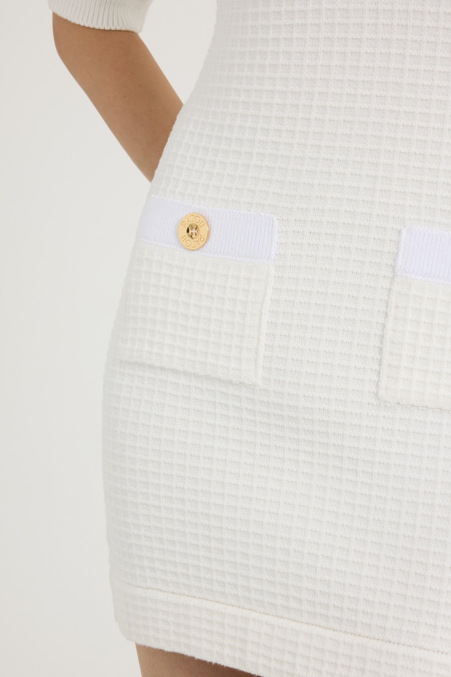 Patou - コットン ワッフル ニット ミニドレス - Ivory - アイボリーのコットン製ドレス。ワッフルニット。スリムフィット。ショート丈。ラウンドネック。ゴールドトーンのパトゥロゴ刻印入りボタン。半袖。胸元にモックポケット、前面にパッチポケット。首元、プラケット、ポケットにコントラストディテール