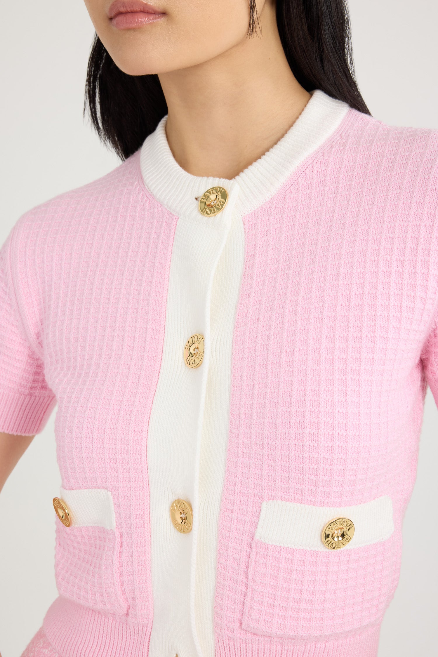 Patou - Cardigan corto in maglia di cotone goffrata - Pink - Cardigan in cotone rosa. Lavorazione goffrata. Vestibilità aderente. Modello corto. Collo tondo. Bottoni oro incisi con il logo Patou. Maniche corte. Tasche a toppa sul davanti. Dettagli a contrasto al collo, sulla pattina e sulle tasche.