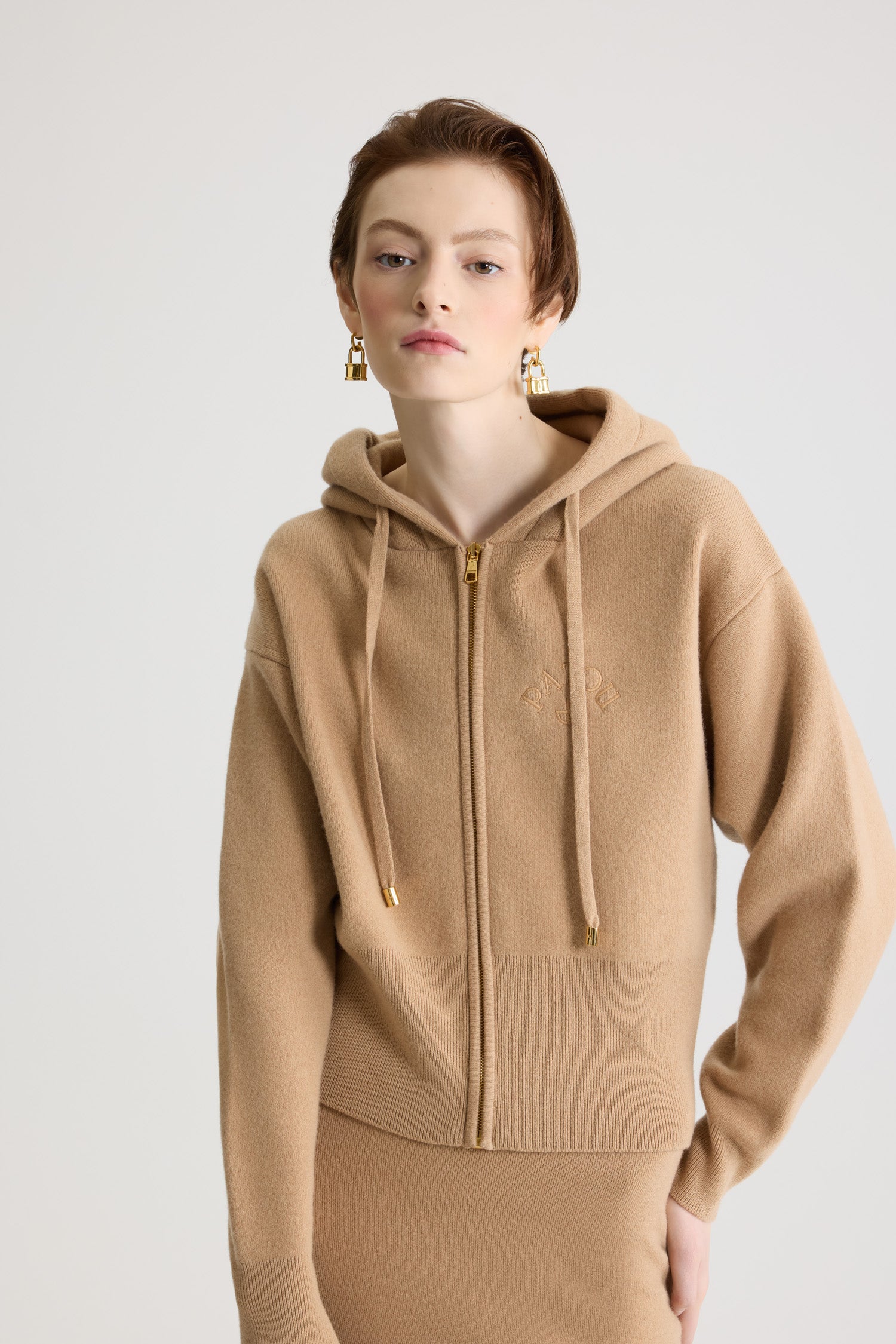 Patou - ウール&カシミア ジップアップ フーディ - Biscuit - ビスケットベージュのメリノウール&カシミア製フーディ。ドローストリング付きフーディ。ドローストリングにゴールドトーンのパトゥロゴ刻印入りチップ付き。前面にゴールドトーンのファスナー。胸にパトゥの刺しゅうロゴとJPモノグラム。リブ編みの袖口と裾。