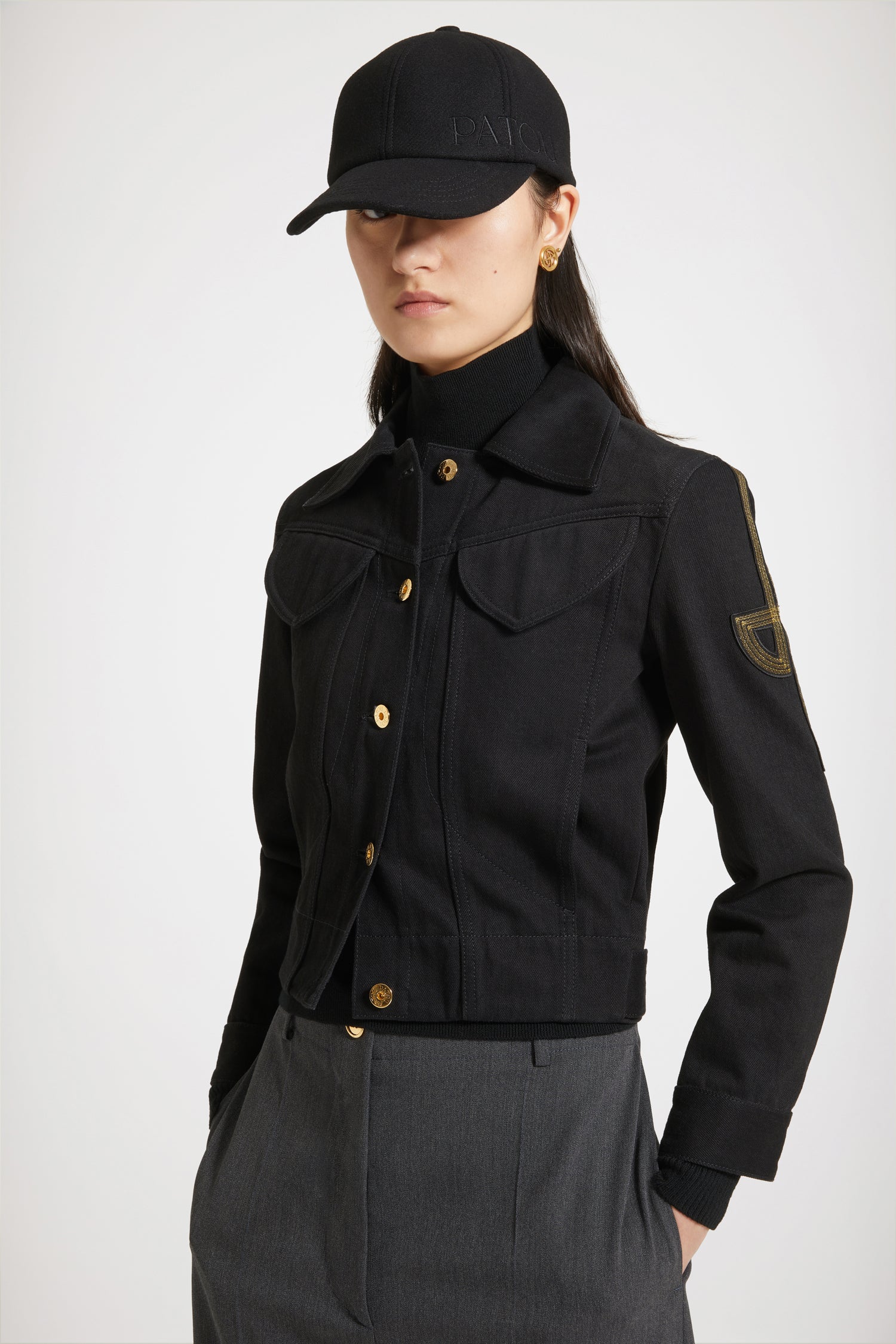 Patou - オーガニックデニム 刺繍ロゴジャケット - Black - ゴールドの文字をまとう新しいデニムがパトゥから登場。 フィットスタイルのオーガニックブラックデニム製ジャケット、コントラストカラーのステッチ入り。左袖にオリジナルJPロゴの刺繍。フロント、ウエスト、袖口にエングレーヴィング入りのゴールドカラーボタン。胸にフラップポケット2個、サイドポケット2個。