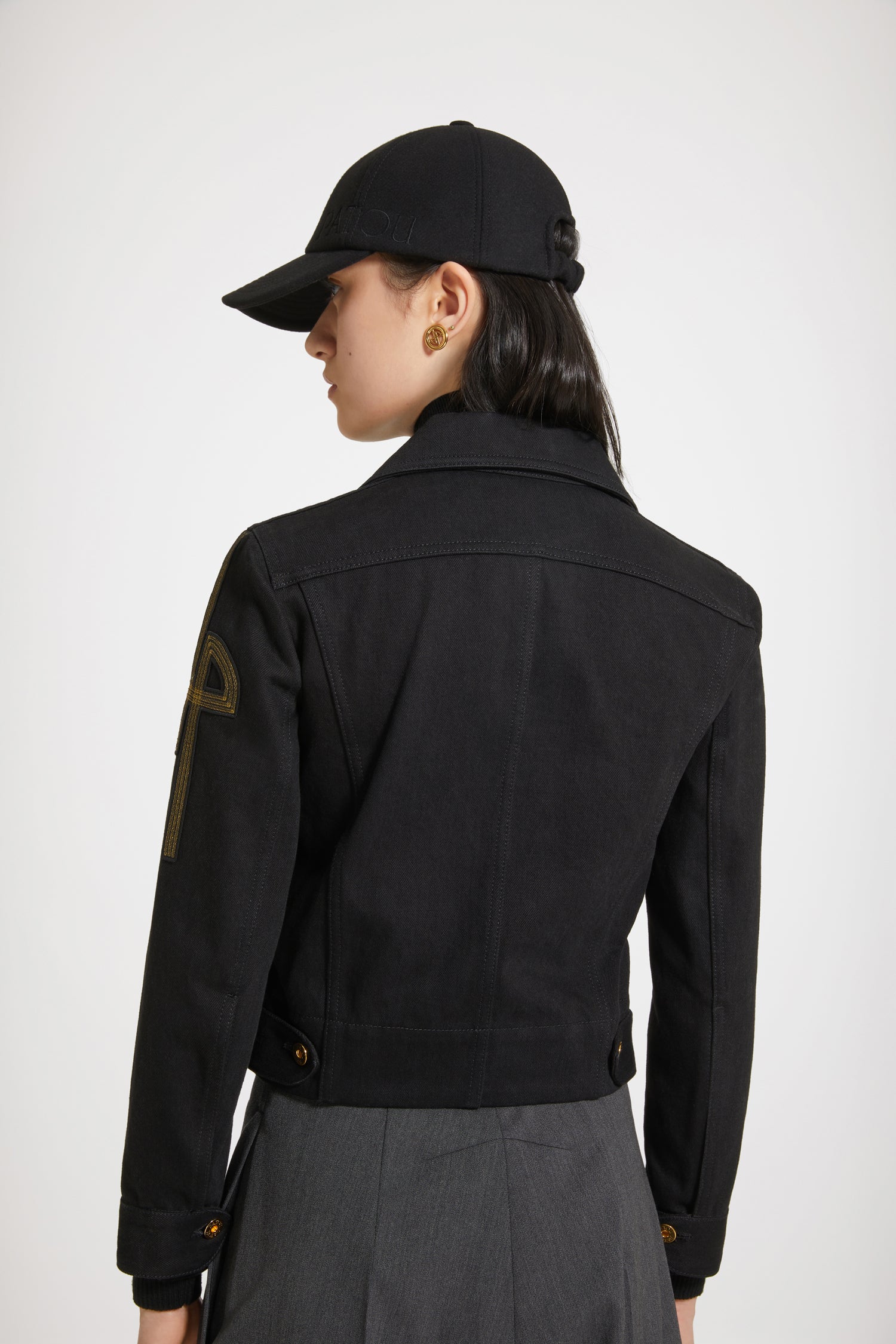 Patou - オーガニックデニム 刺繍ロゴジャケット - Black - ゴールドの文字をまとう新しいデニムがパトゥから登場。 フィットスタイルのオーガニックブラックデニム製ジャケット、コントラストカラーのステッチ入り。左袖にオリジナルJPロゴの刺繍。フロント、ウエスト、袖口にエングレーヴィング入りのゴールドカラーボタン。胸にフラップポケット2個、サイドポケット2個。