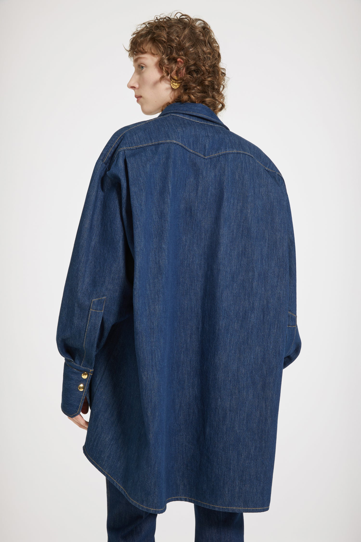 Patou - Surchemise en denim bio - Rodeo Blue - La surchemise se superpose et s'impose. Surchemise en denim de coton bio bleu rodéo. Silhouette ample. Manches ballon. Boutons pression dorés sur le devant et aux poignets. Patou brodé sur le devant. Couture arrondie signature au dos.