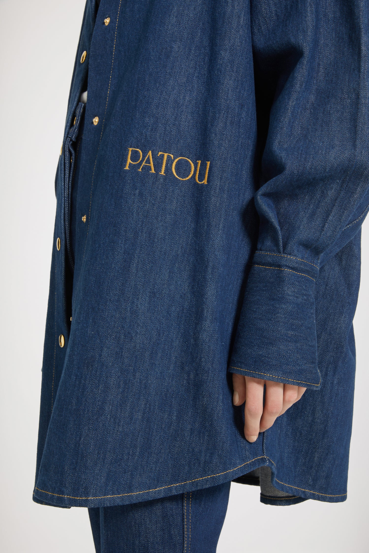 Patou - Surchemise en denim bio - Rodeo Blue - La surchemise se superpose et s'impose. Surchemise en denim de coton bio bleu rodéo. Silhouette ample. Manches ballon. Boutons pression dorés sur le devant et aux poignets. Patou brodé sur le devant. Couture arrondie signature au dos.