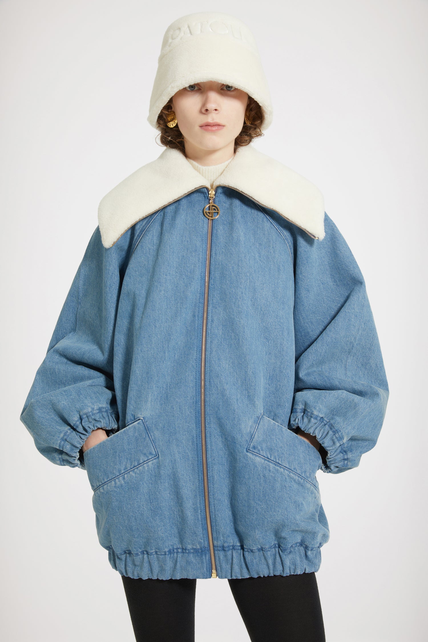Patou - Oversized jacket in organic cotton denim and faux shearling - Ice Blue - Chez Patou, sherpas are making a comeback!Ice Blue organic cotton denim jacket. Sustainable laser fading. Sherpa-inspired design with faux shearling lining. Oversized cocoon silhouette. Exaggerated collar. Gold-tone zip fastening with signature JP puller. Raglan sleeves. Wide diagonal welt pockets. Elasticated cuffs and hem. Embroidered Patou logo at the back.Oversize style (select one size down for a fitted look).