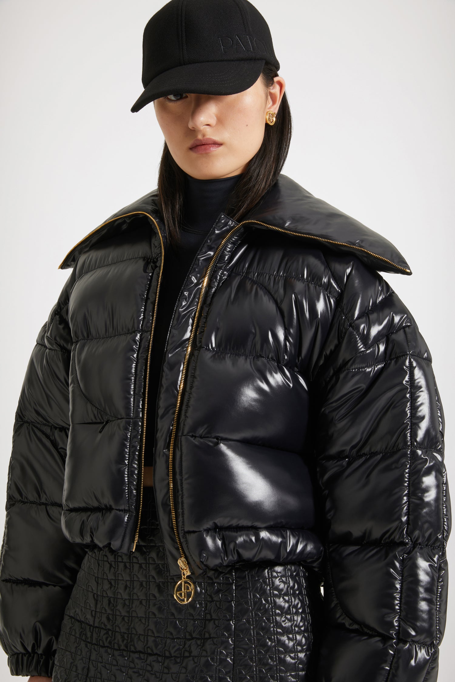 Patou - Short puffer jacket in eco-friendly polyamide - Black - The JP stamp of approval!Black eco-friendly polyamide jacket. Short padded style. High collar. Gold-tone zip with signature JP puller. Maxi JP matelassé at the back. Pockets at the sides. Drawstring waist. Elasticated cuffs.This jacket is short.