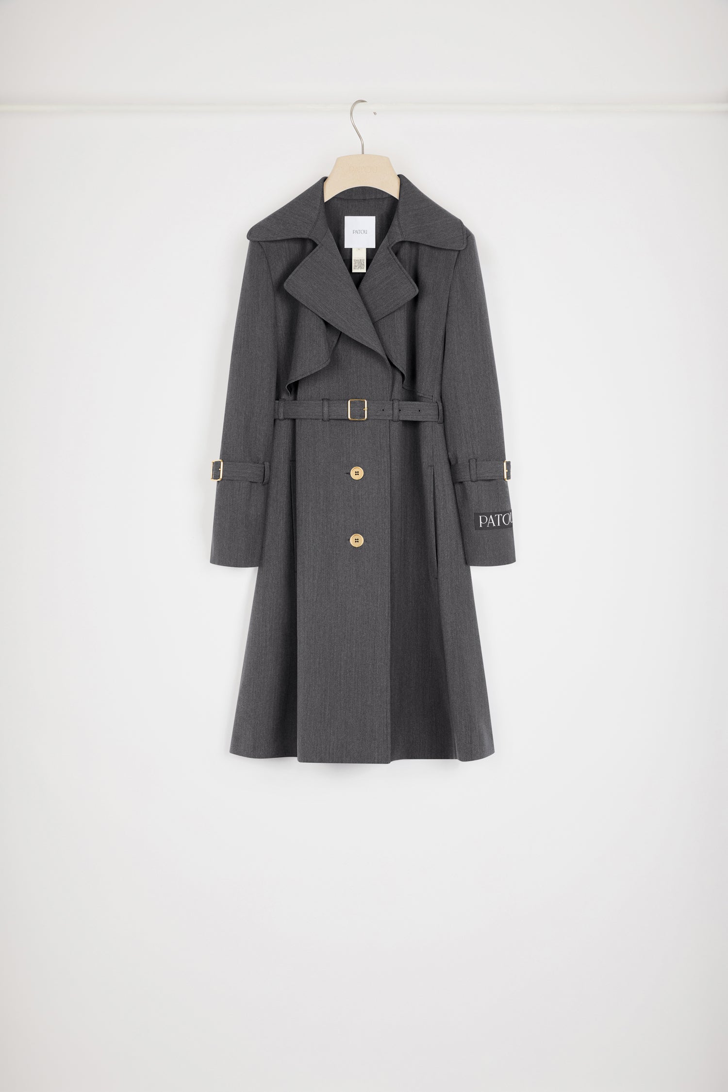 Patou - Trench coat in technical wool twill - Anthracite - The trench goes French.Anthracite grey technical wool twill trench coat. Tailored single-breasted silhouette. Knee length. Notch lapels. Storm flap at the front. Gold-tone Patou-engraved buttons at the front. Adjustable gold-tone buckle belt that sits at the waist. Side seam patch pockets at the front. Belted cuffs. Signature Patou label on the left arm. Signature curved seam at the back. Single back vent with gold-tone Patou-engraved button.