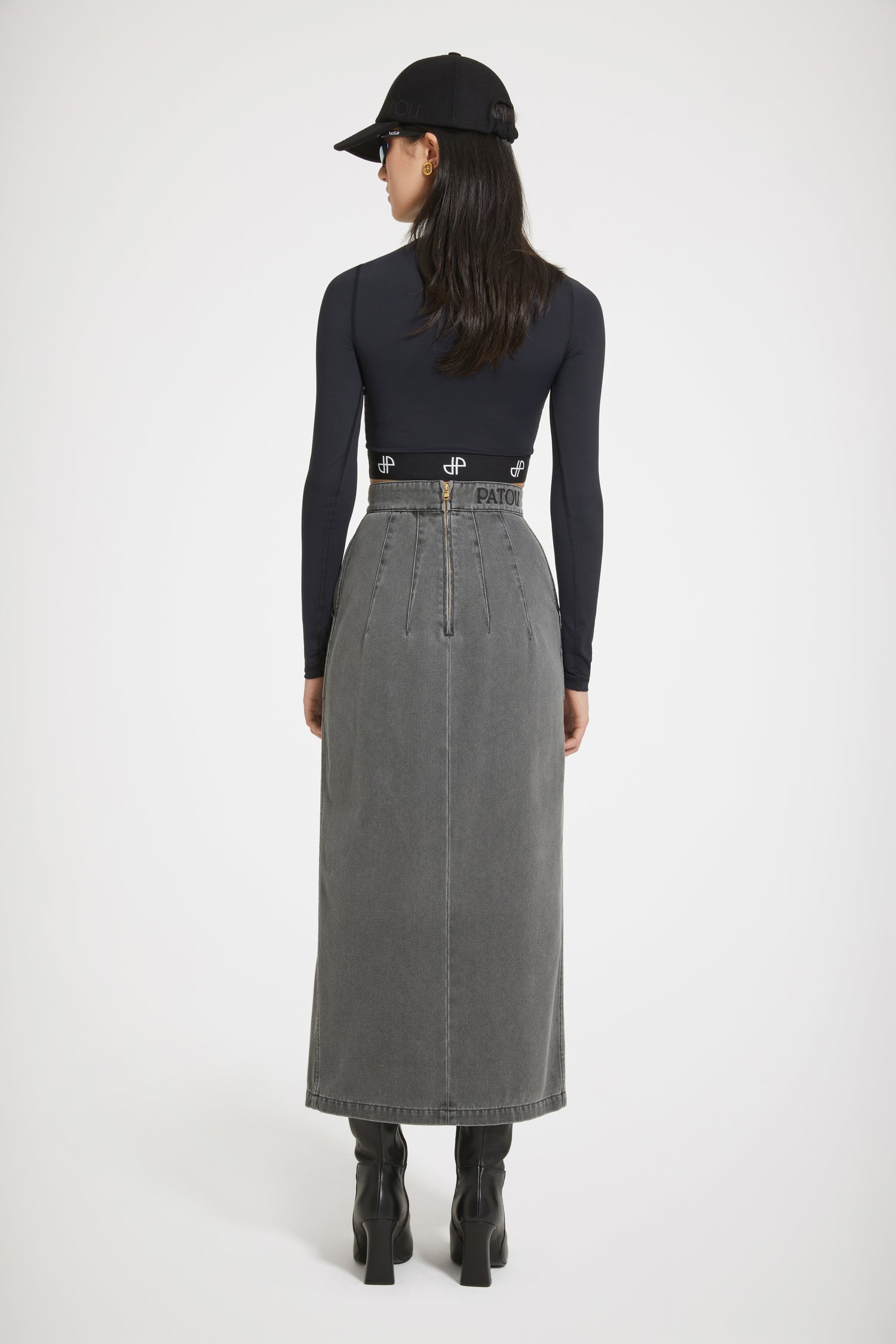 Patou - Slit midi skirt in organic cotton denim - Anthracite - The ease of denim, the allure of couture.Anthracite grey organic cotton denim skirt. Sustainable laser fading. High waist. Midi length. Fitted silhouette with multiple darts at the back. Gold-tone Patou-engraved Medallion embellishment at the front. Belt loops. High slit at the front. Pockets at the sides. Zip fastening at the back. Patou embroidery at the waist.Tight fit at the waist.The ornament can be removed.