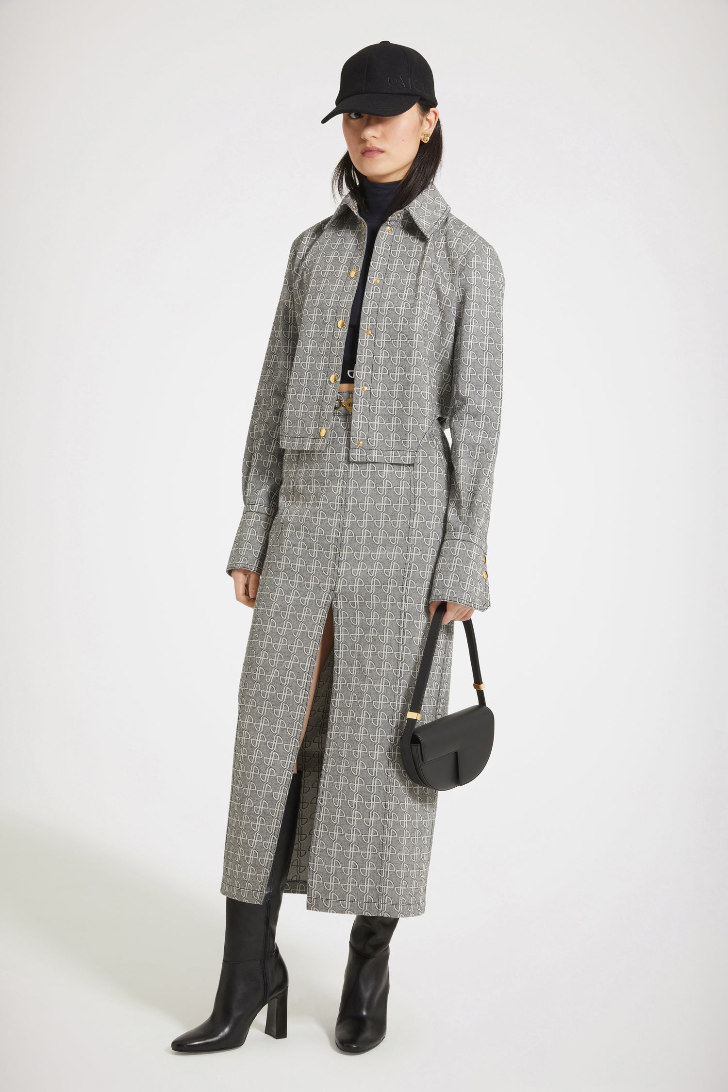 Patou - Jupe midi fendue en jacquard de coton - Black JP link - Le fendu inattendu.Jupe en jacquard de coton noir et blanc. Motif JP allover. Taille haute. Longueur midi. Silhouette ajustée avec pinces au dos. Médaillon doré gravé Patou sur le devant. Passants de ceinture. Fente haute sur le devant. Poches latérales. Zip au dos. Patou brodé à la taille.Modèle ajusté à la taille.Le médaillon peut être enlevé.