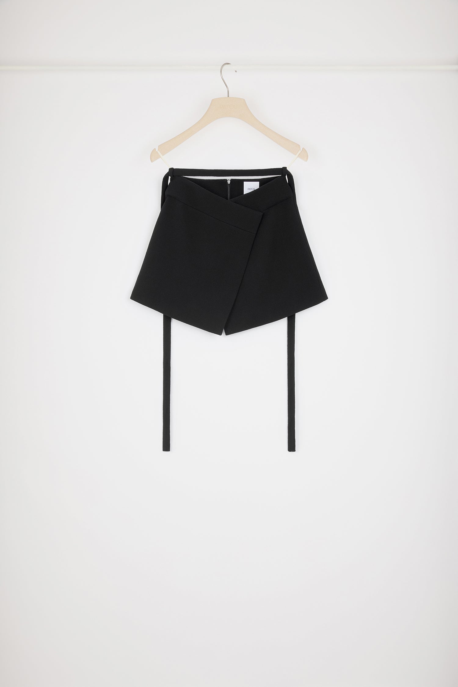 Patou - Wrap skirt in wool crepe - Black - The art of wrapping it up.Black double wool crepe skirt. Mid rise. Short length. A-line wrap silhouette. Detachable belt that ties at the back. Zip fastening at the back.This style is very short.
