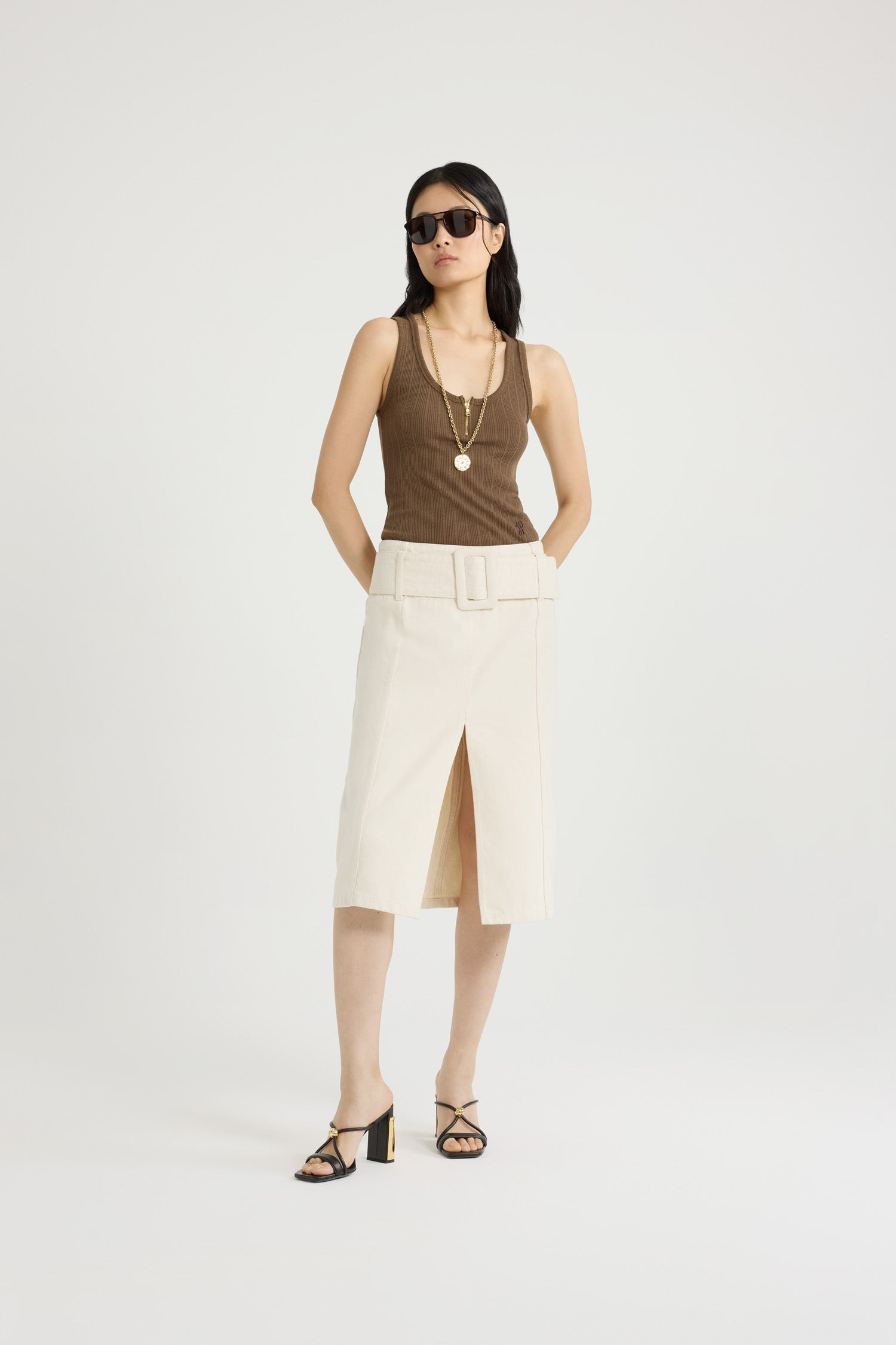 Patou - Belted midi skirt in cotton denim - Natural - Natural off-white cotton denim skirt. Midi length. Low waist. Removable wide fabric belt. High slit at the front. Zip fastening at the back. Lined.
