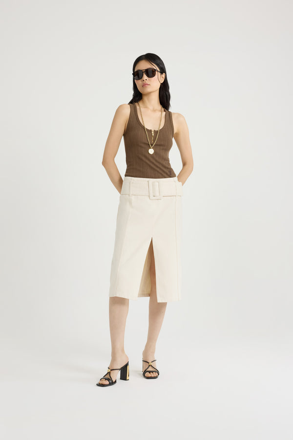 Patou - Jupe midi ceinturée en denim de coton - Natural - Jupe en denim de coton naturel écru. Longueur midi. Taille basse. Ceinture large amovible. Fente haute sur le devant. Fermeture par zip au dos. Modèle doublé.