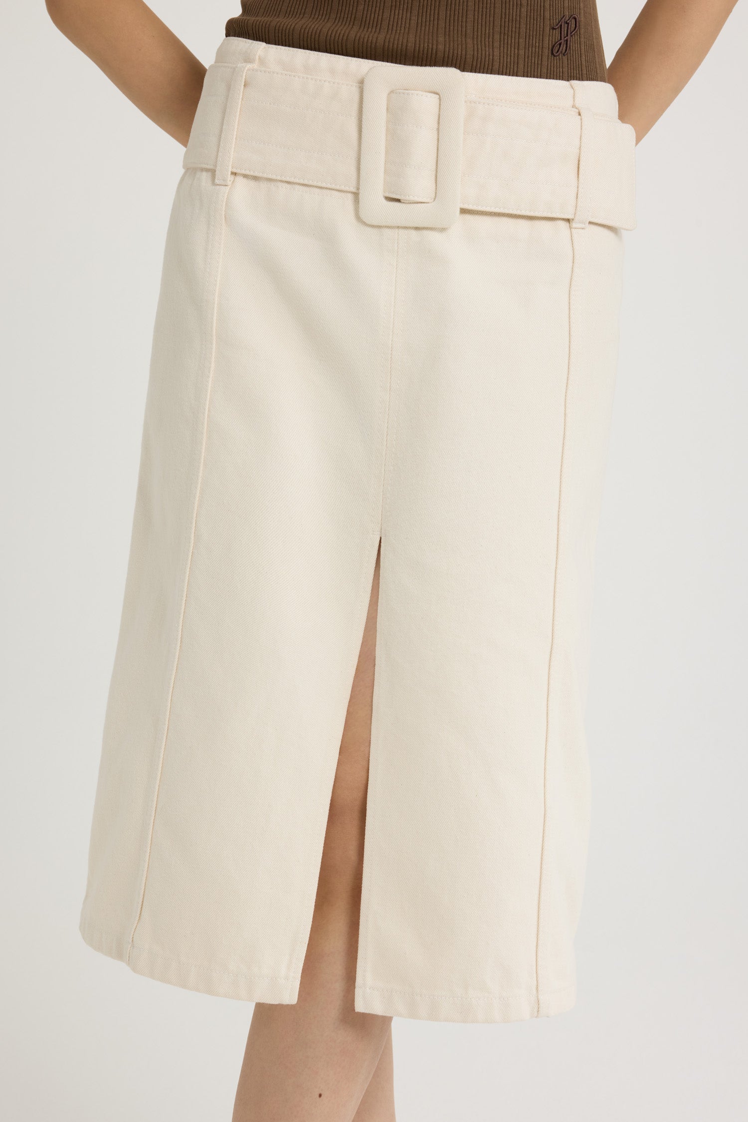 Patou - Belted midi skirt in cotton denim - Natural - Natural off-white cotton denim skirt. Midi length. Low waist. Removable wide fabric belt. High slit at the front. Zip fastening at the back. Lined.