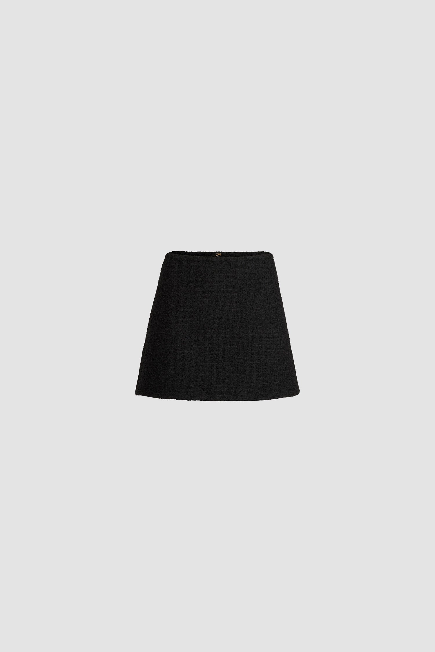 Patou - A-line mini skirt in sustainable wool blend tweed - Black - Black sustainable wool blend tweed skirt. Short length. Mid waist. A-line silhouette. Zip fastening at the back. Darts at the back. Lined.
