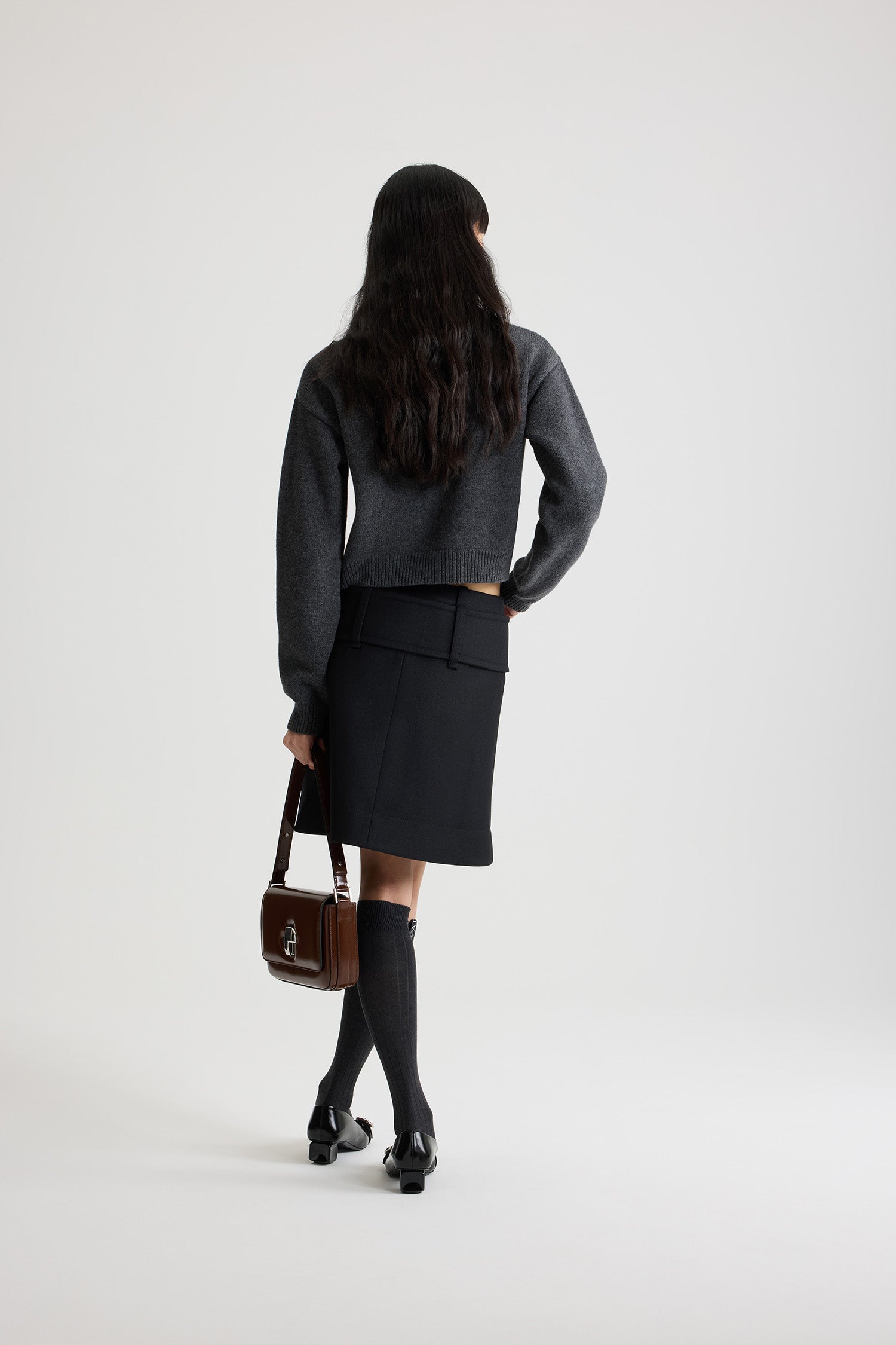 Patou - Minigonna con cintura e zip sul davanti in lana - Black - Gonna in lana nera. Modello corto. Vita bassa. Chiusura con zip oro a doppio cursore sul davanti. Cintura ampia in tessuto sui fianchi con fibbia rivestita in tessuto e D-ring oro. Tasche basse sul davanti. Modello foderato.