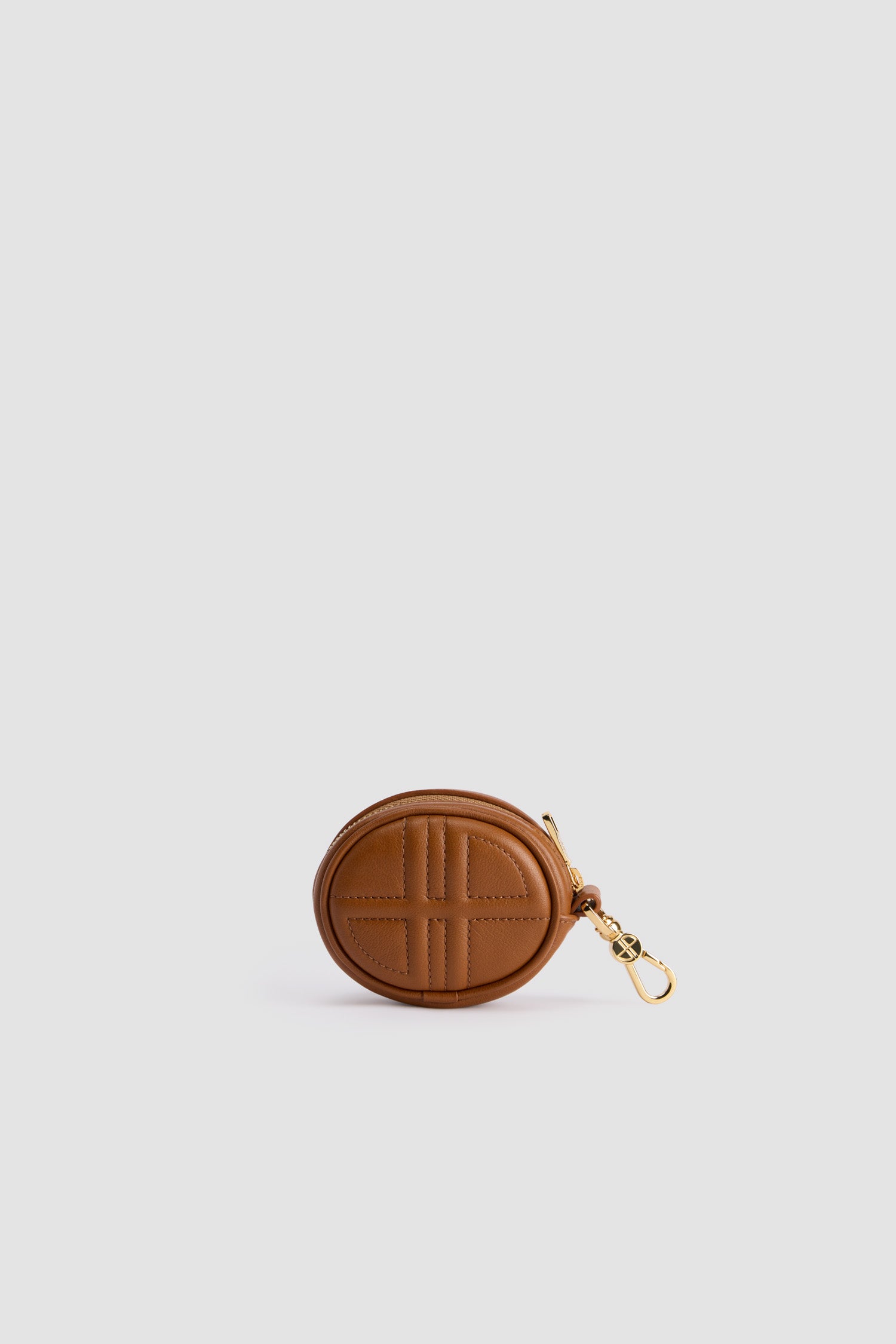 Patou - Mini JP pouch in leather - Autumn Leaf - Autumn Leaf brown leather pouch. Can be used as a bag charm. Oval shape with a foam-padded 3D JP monogram at the front. Embossed Patou at the back. Zip fastening. Gold-tone hook. Designed to fit wireless earphones.