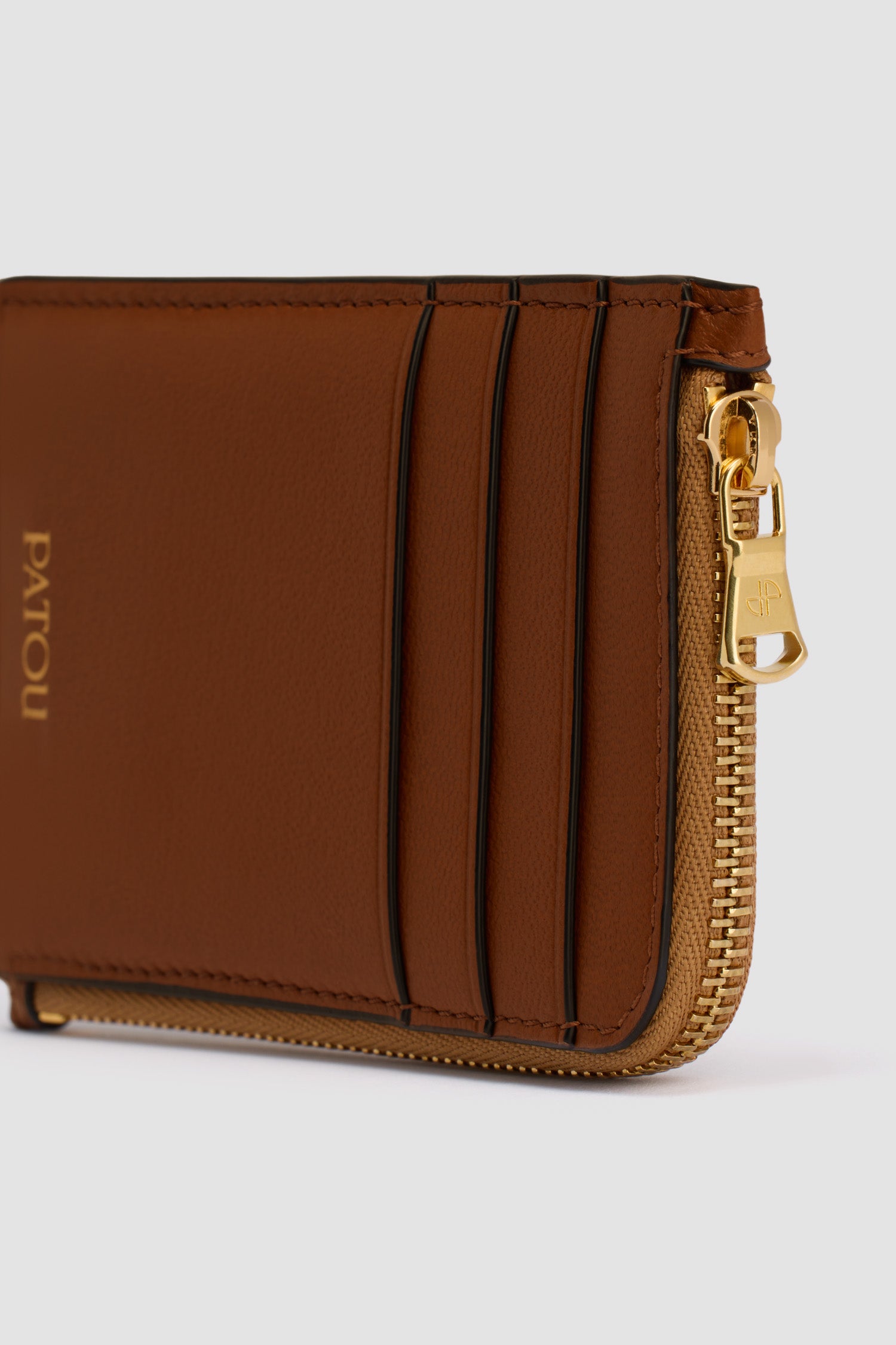 Patou - Patou coin cardholder in leather - Black Chestnut - Black Chestnut two-tone leather coin cardholder. Three card slots at the front, one cut-out card slot at the back. Zipped coin cardholder. Gold embossed Patou.