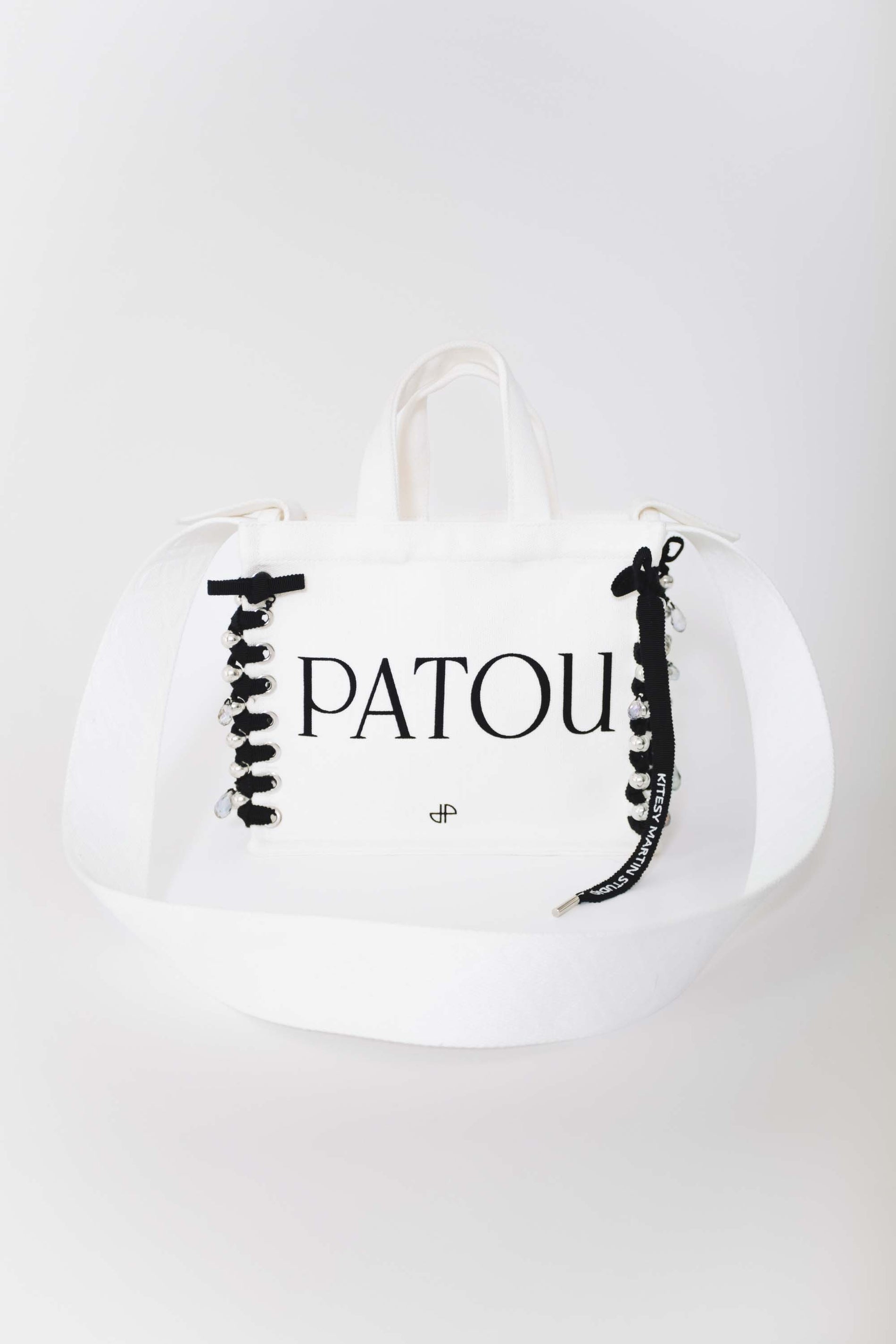 Patou - Patou Upcycling canvas tote in organic cotton - Black - For its inaugural edition, Patou partners with French designer Kitesy Martin, founder of Kitesy Martin Studio.Cream organic cotton tote. Patou lettering logo and JP monogram in black. White embossed shoulder strap with gold buttons. Two top handles. Can be carried by hand or on the shoulder.Limited Edition.