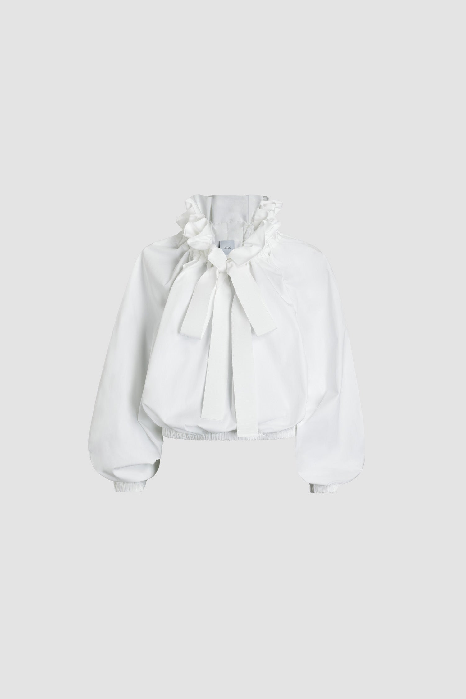 Patou - La Patou Blouse in recycled faille - White - White recycled polyester faille top. High volume silhouette that can be worn knotted at the neck or off the shoulders. Drawstring collar with flounce at the front and long grosgrain ties. Batwing sleeves with elasticated cuffs. Elasticated waist.This top is part of the Cérémonie capsule collection designed with love for very special occasions.