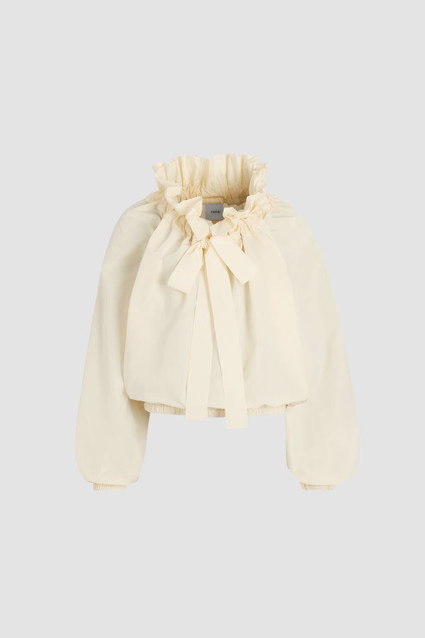 Patou - Haut à manches bouffantes en faille recyclée - Ivory - Haut en faille recyclée ivoire. Silhouette volumineuse. Col à coulisse avec détail de fronce et gros-grain. Manches chauve-souris resserrées aux poignets. Taille élastiquée.Ce top fait partie de la collection Cérémonie créée pour les occasions spéciales.